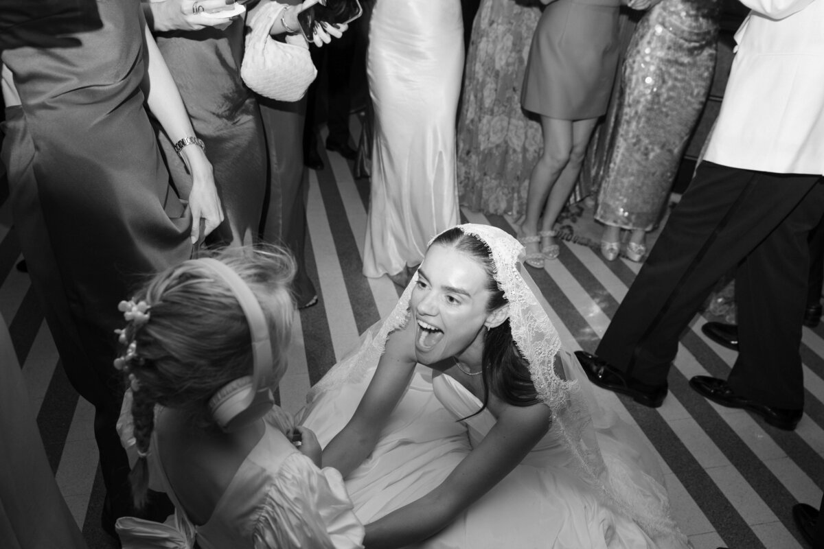 Bride dancing in wedding dress surrounded by partygoers

