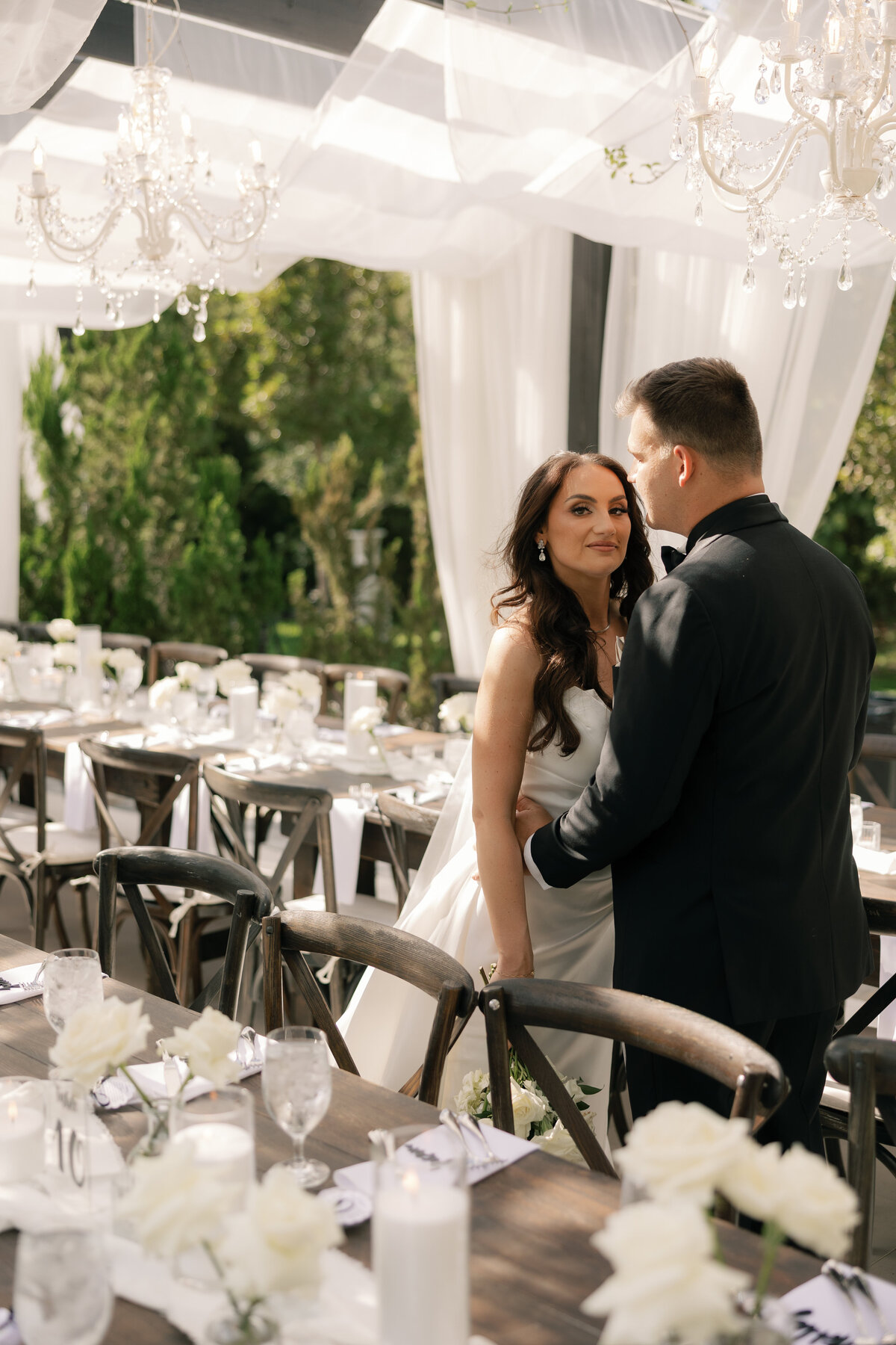 Elegant outdoor reception under chandeliers at La Casa Toscana wedding 
