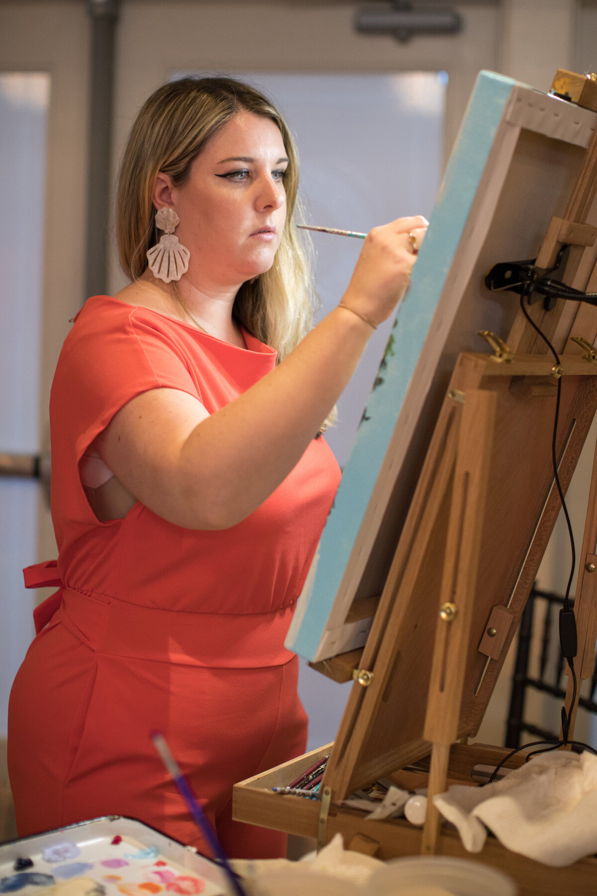 Artist focused on wedding painting at indoor wedding reception