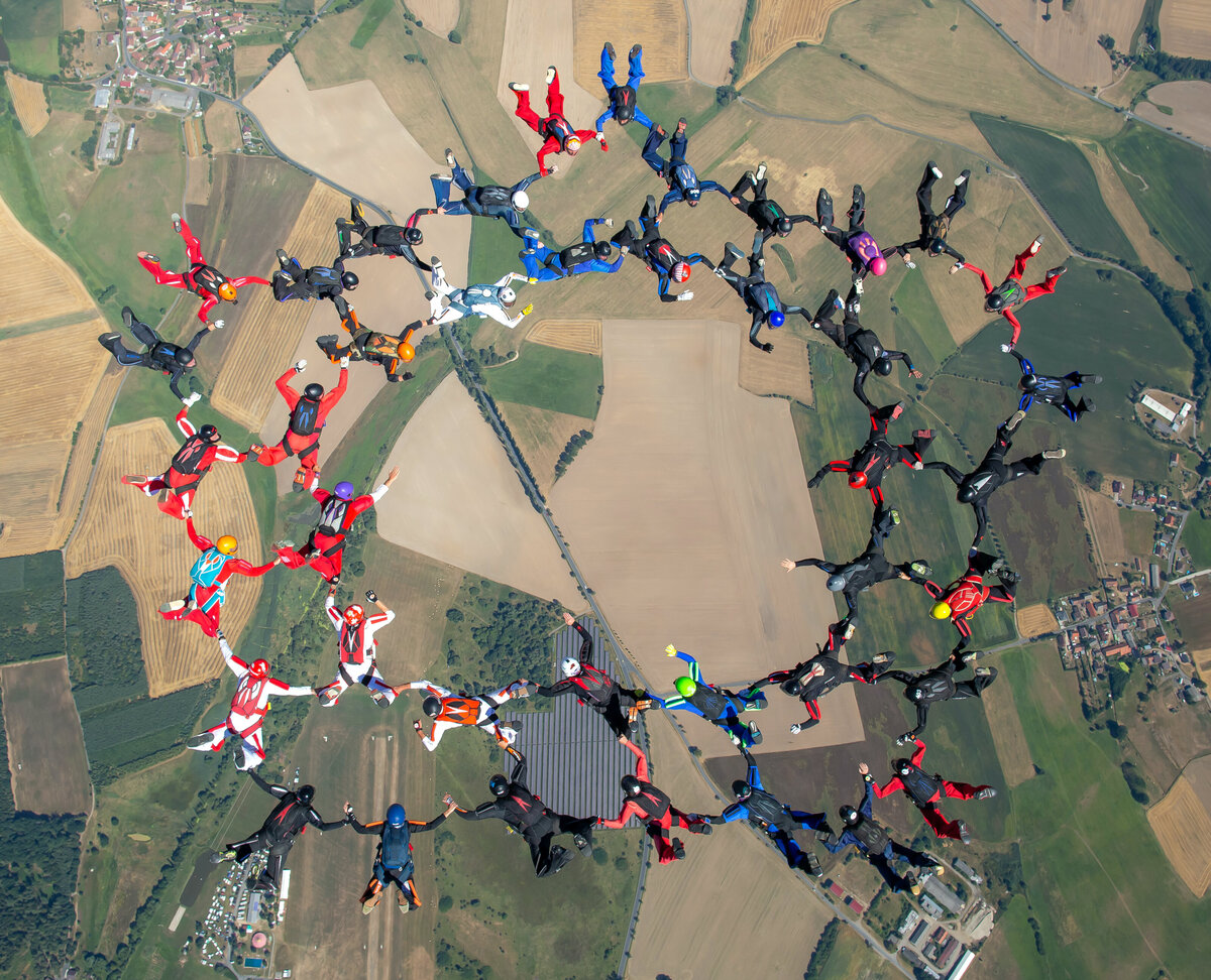 Das Bild zeigt eine Formation von Fallschirmspringern über dem Sprungplatz Skydive Pink Klatovy