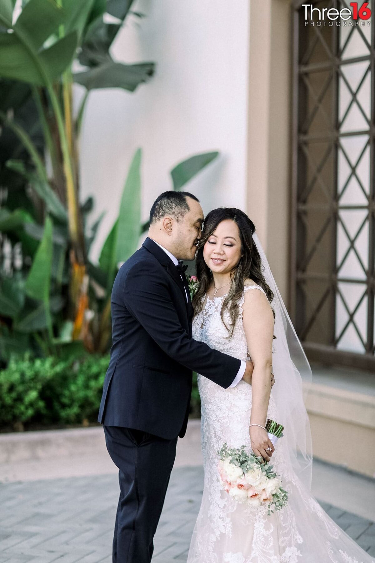 Groom whispers into his Bride's ear during photo session