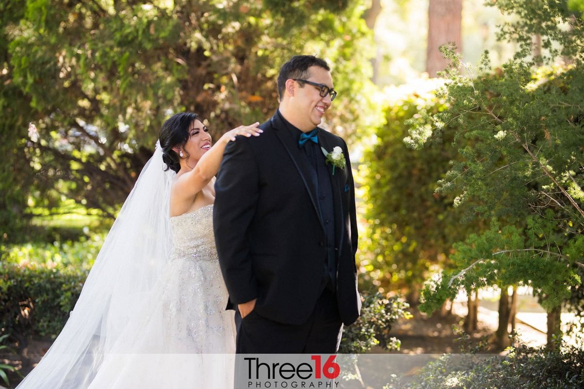 Bride taps Groom on shoulder right before he first sees her in her wedding gown