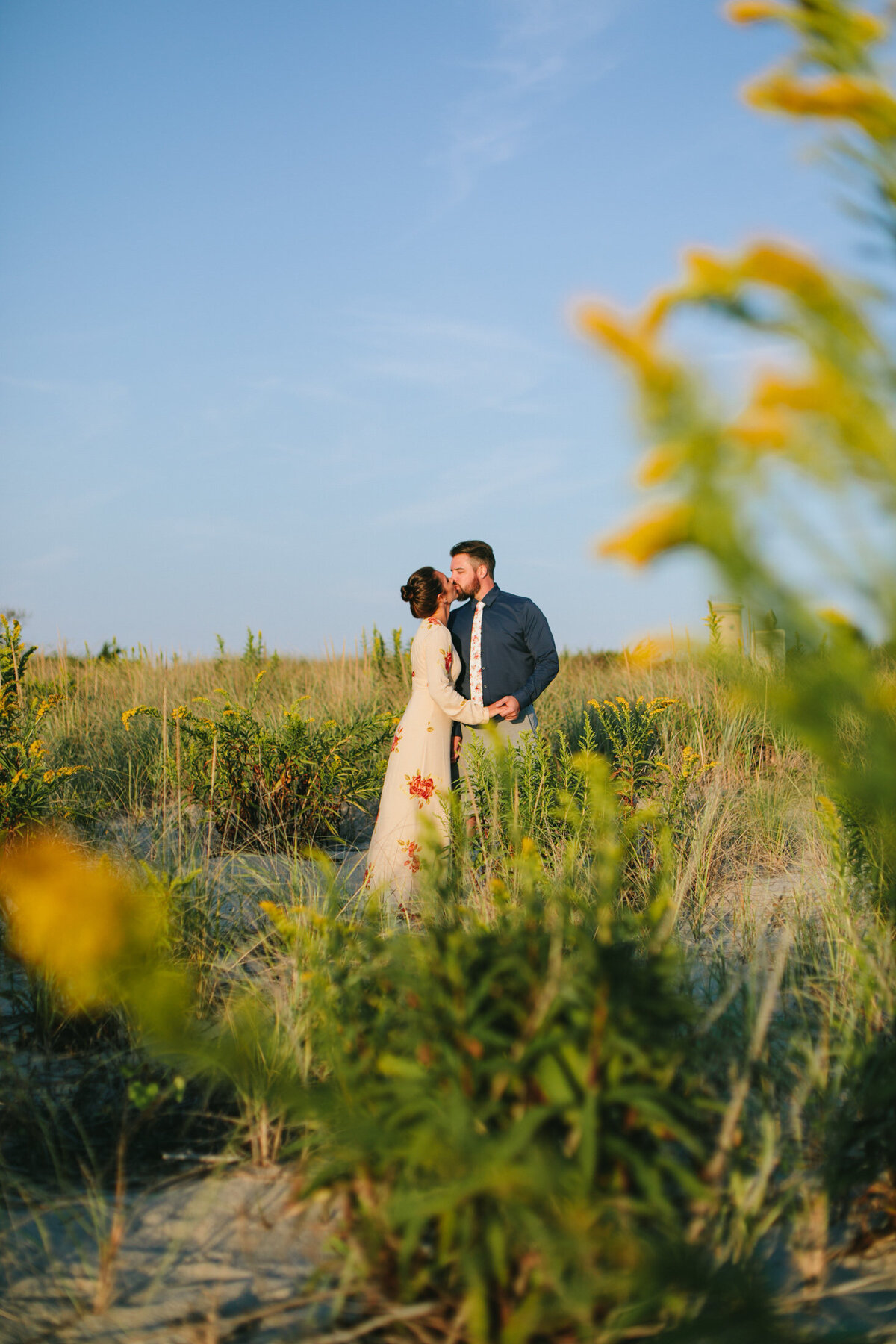 A couple kissing in the middle of tall grass 