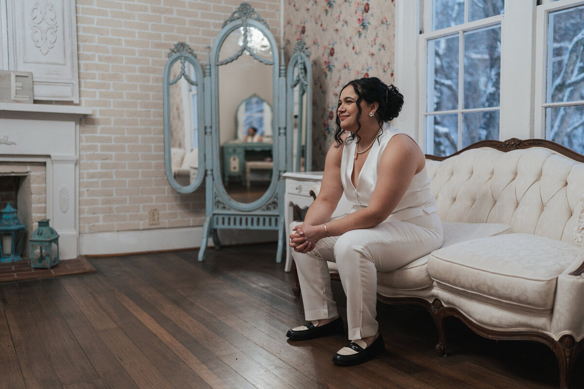 Bride sits on the edge of an antique sofa 