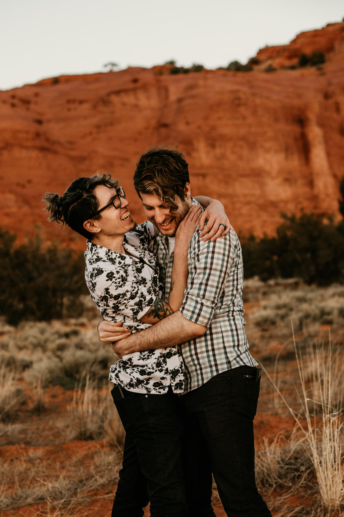 same sex couple tickling and laughing in the desert