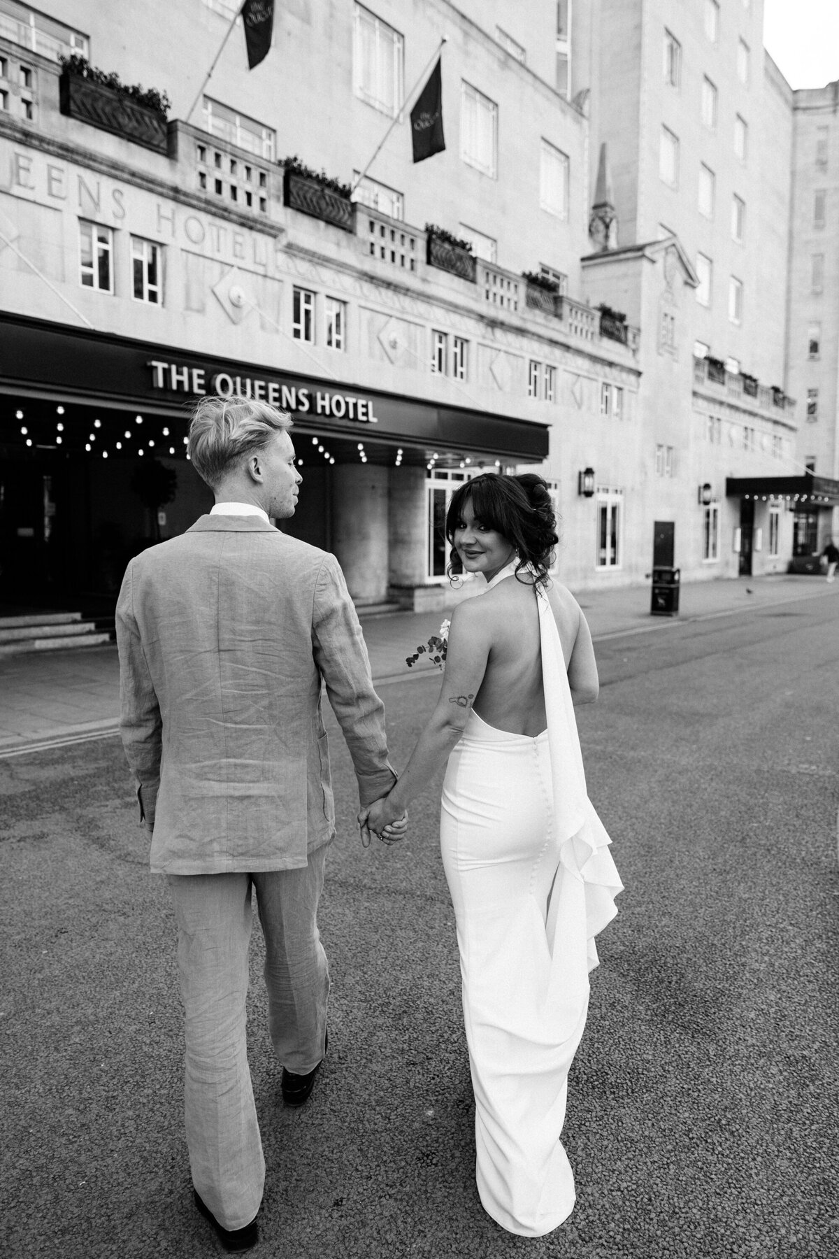 Bride and groom walking by The Queens Hotel in Leeds city centre