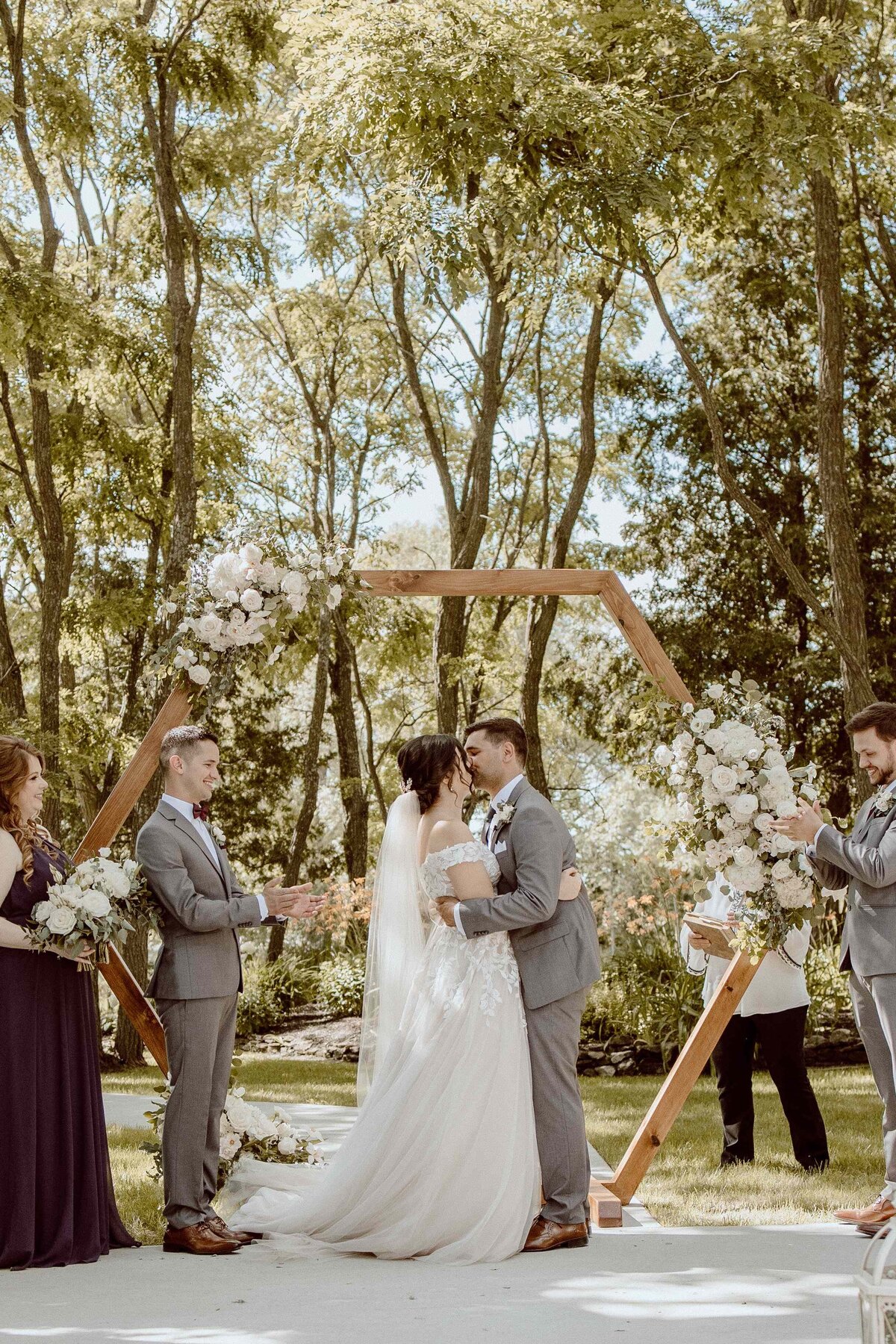bride and groom kissing at altar