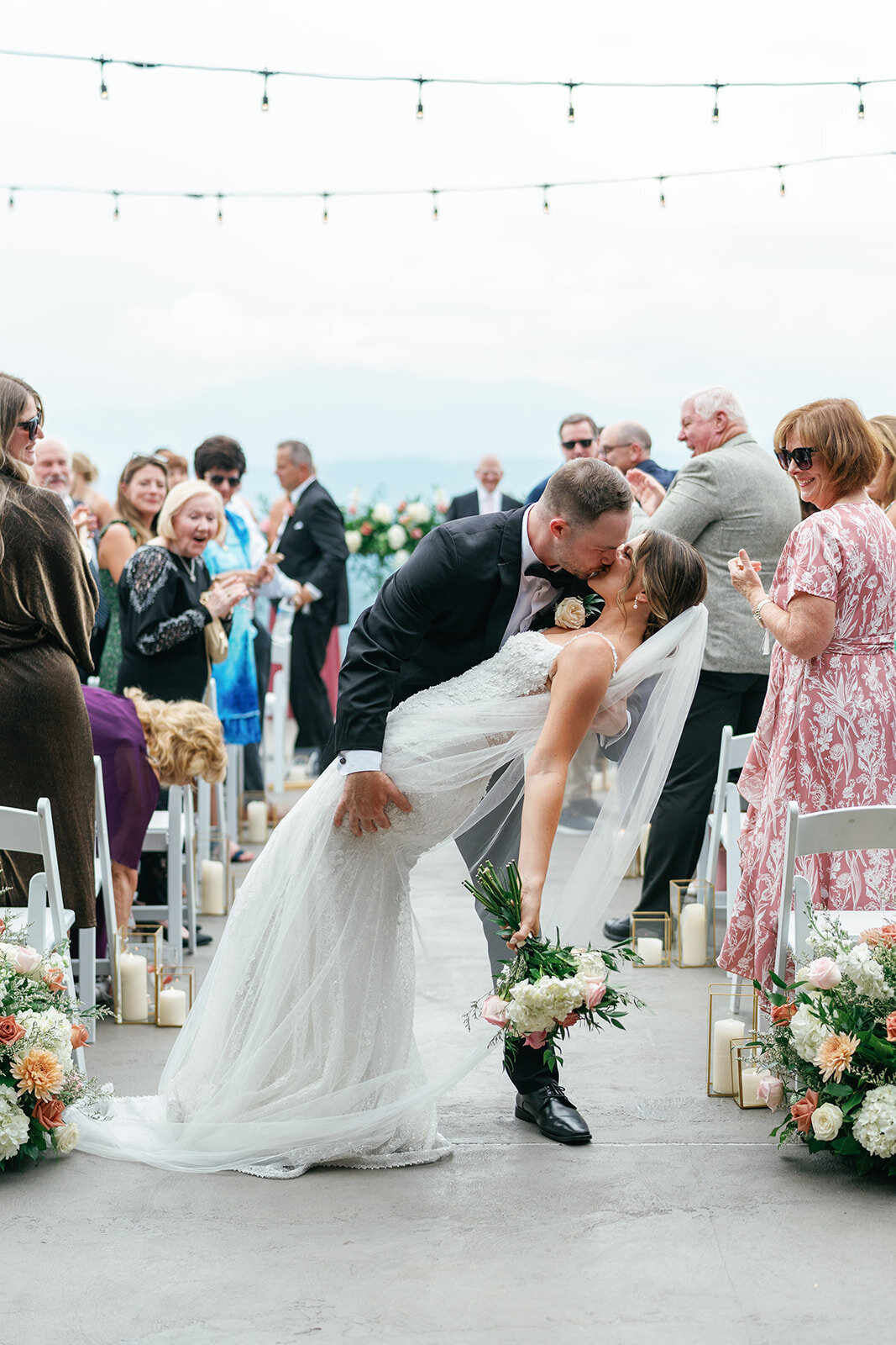 Groom dipping his bride for a kiss after their wedding ceremony