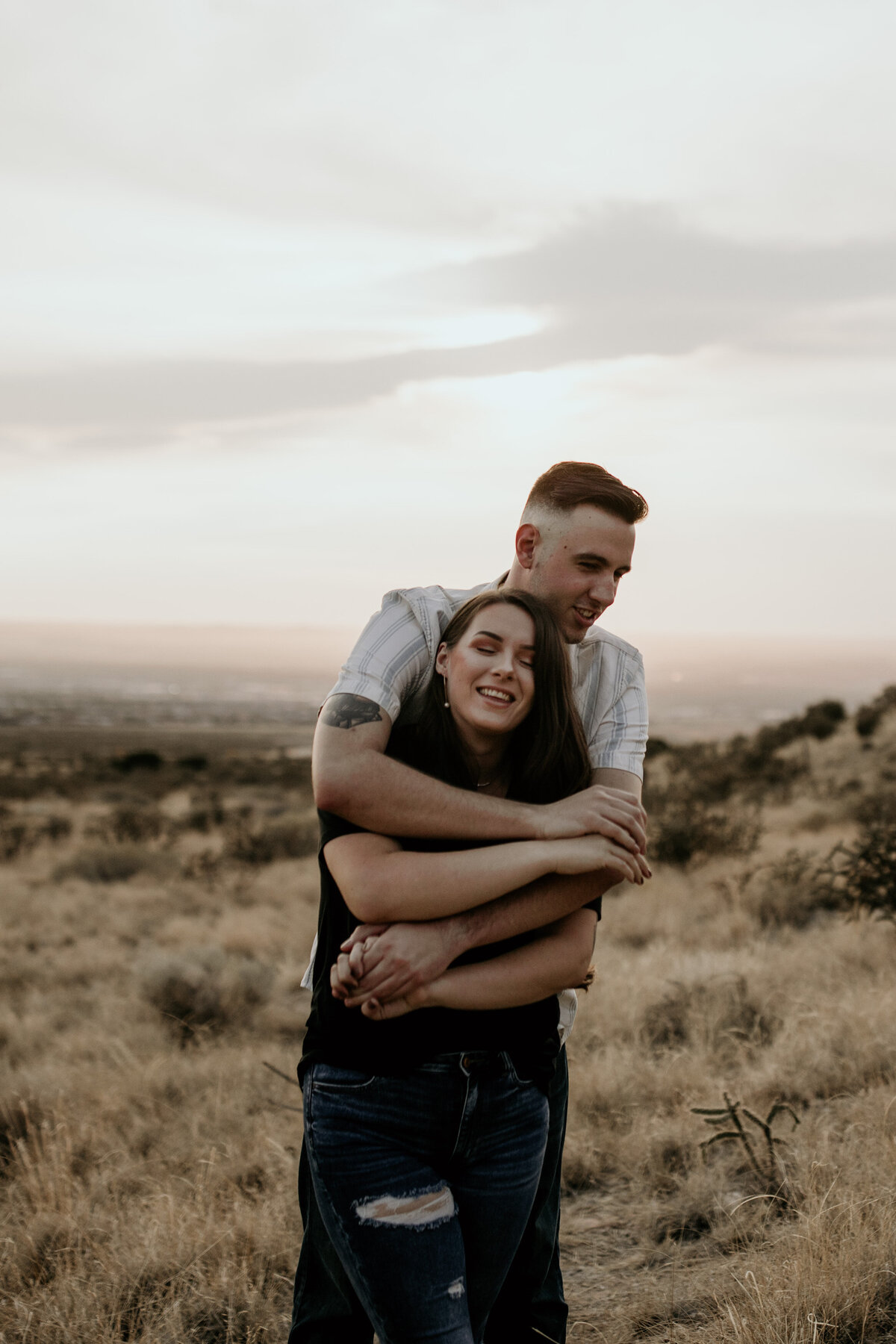 man hugging fiancé from behind in Albuquerque