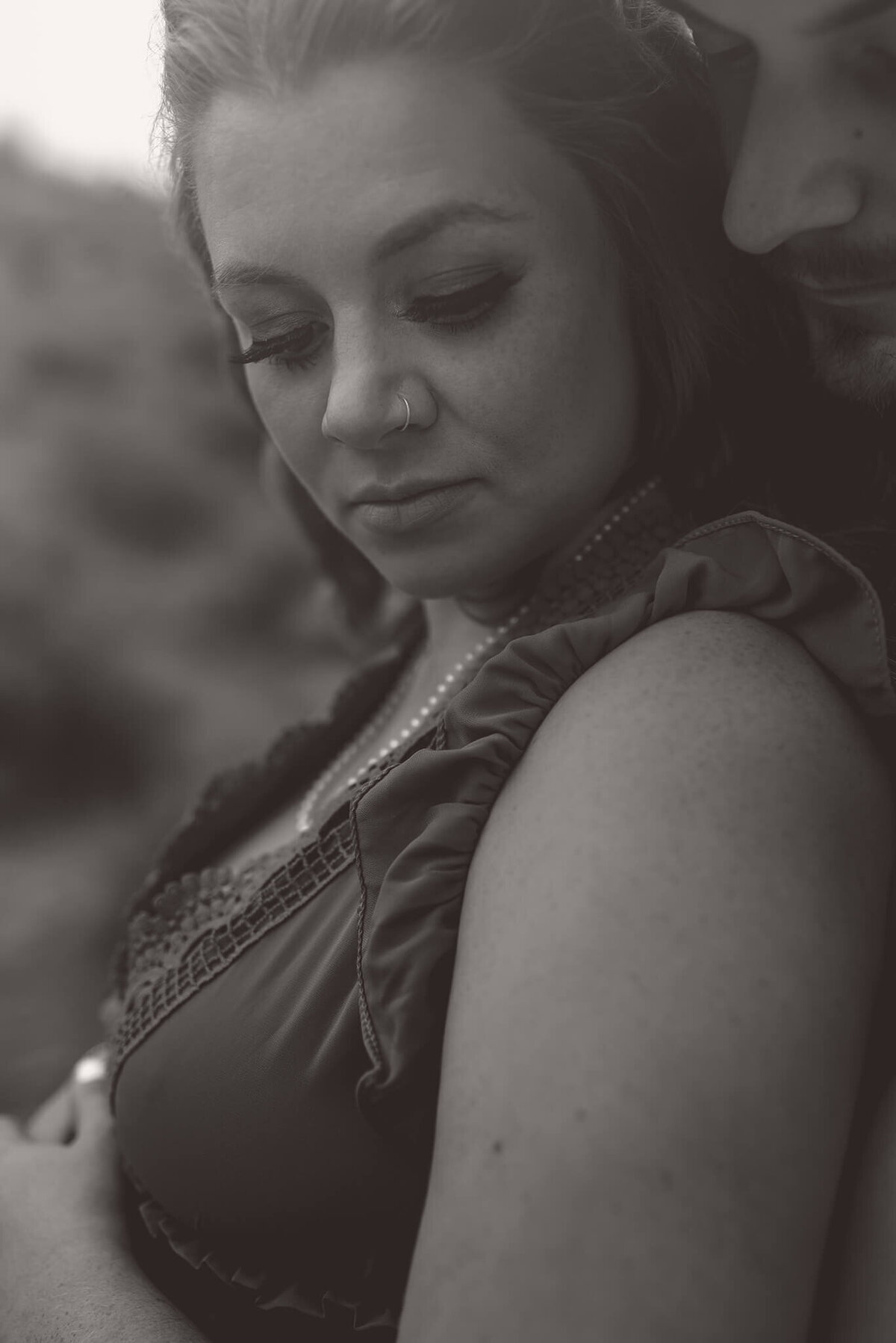 An up close black and white shot of a couple embracing. Portrait by Brittany Danielle