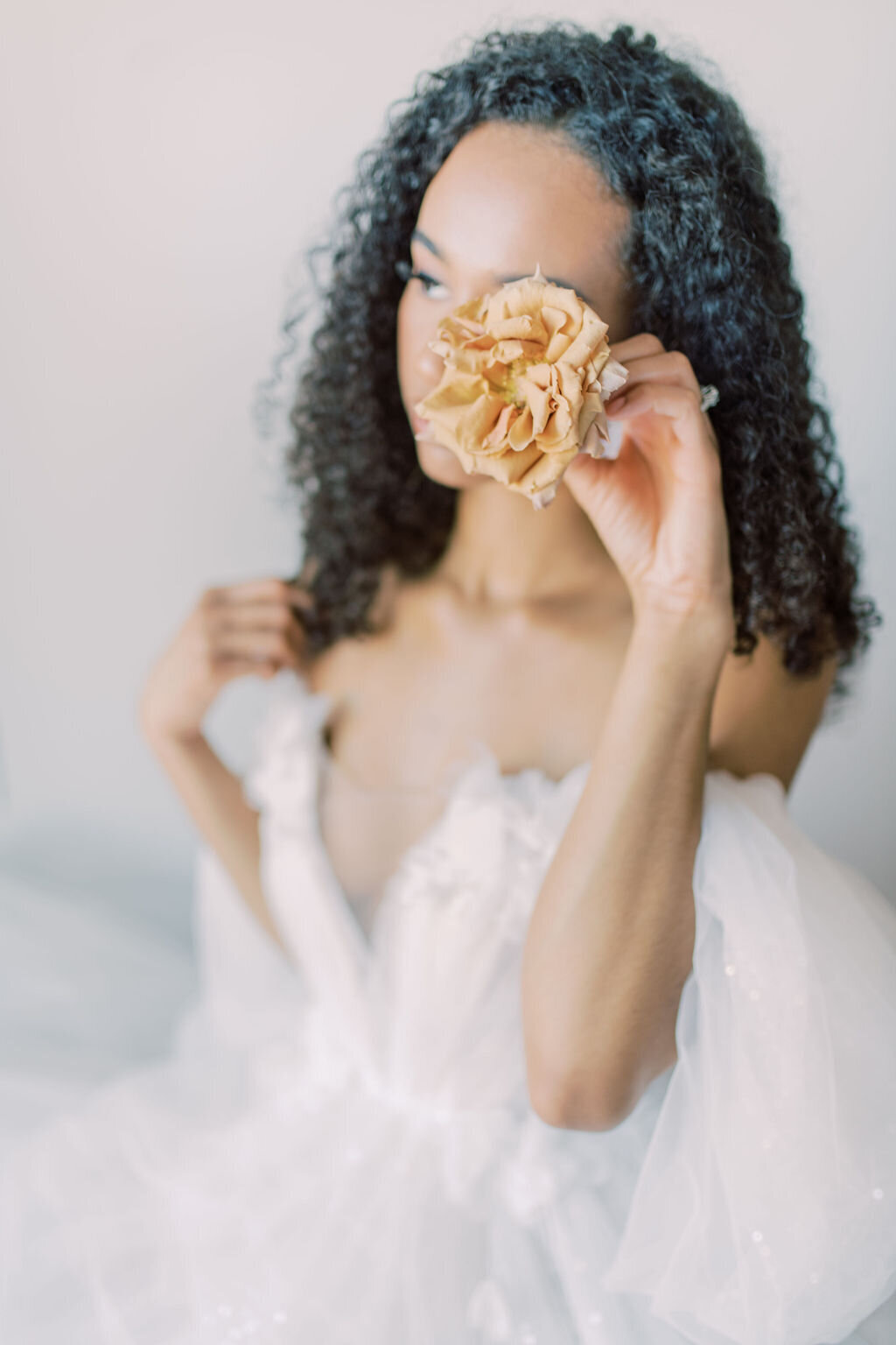 Bride covering the flower with one eye. In Toronto