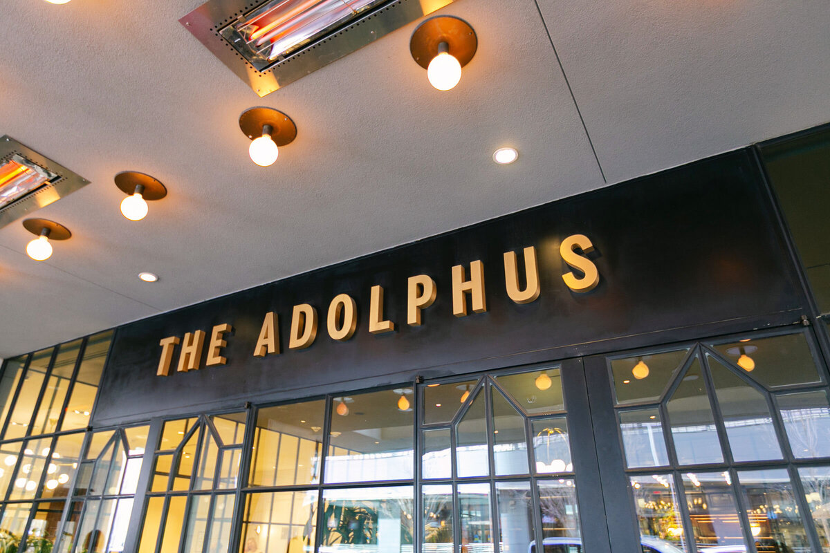 entrance of The Adolphus hotel in Dallas featuring the hotel’s sign, showcasing the iconic venue for weddings and events in the city.