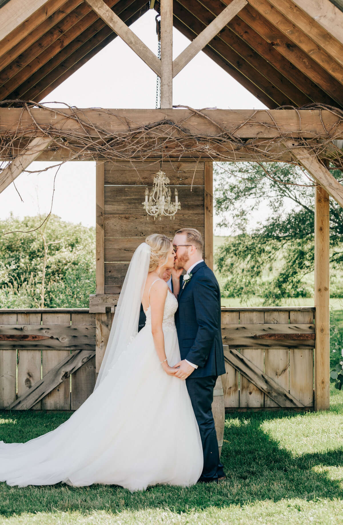 Bride and groom first kiss at luxurious outdoor ceremony