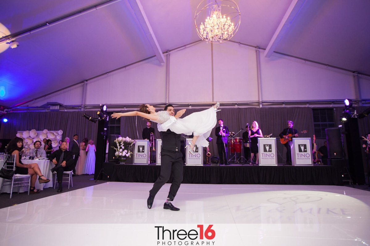 Groom lifts his Bride in the air during their first dance
