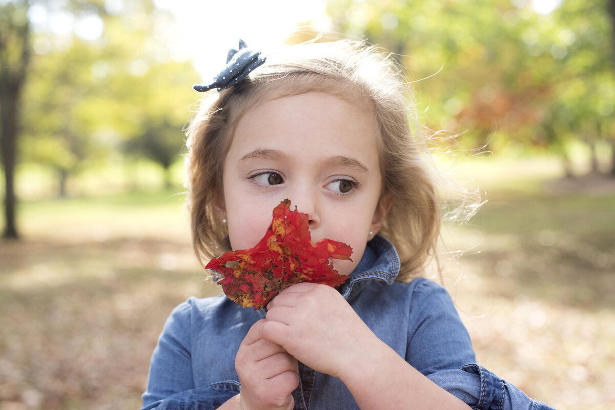 A small child smelling a flower 