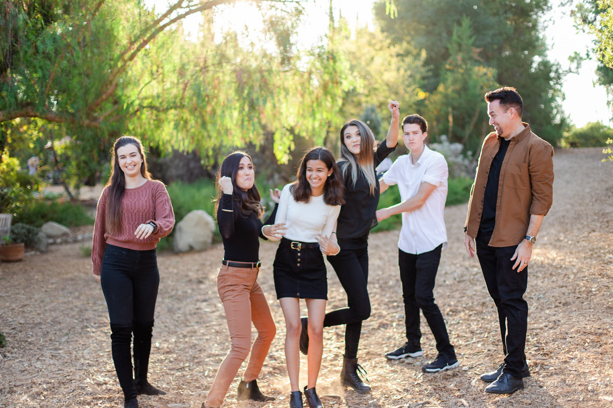 family laughs and dances in the glowy sun, photo by Love is Magic Photo