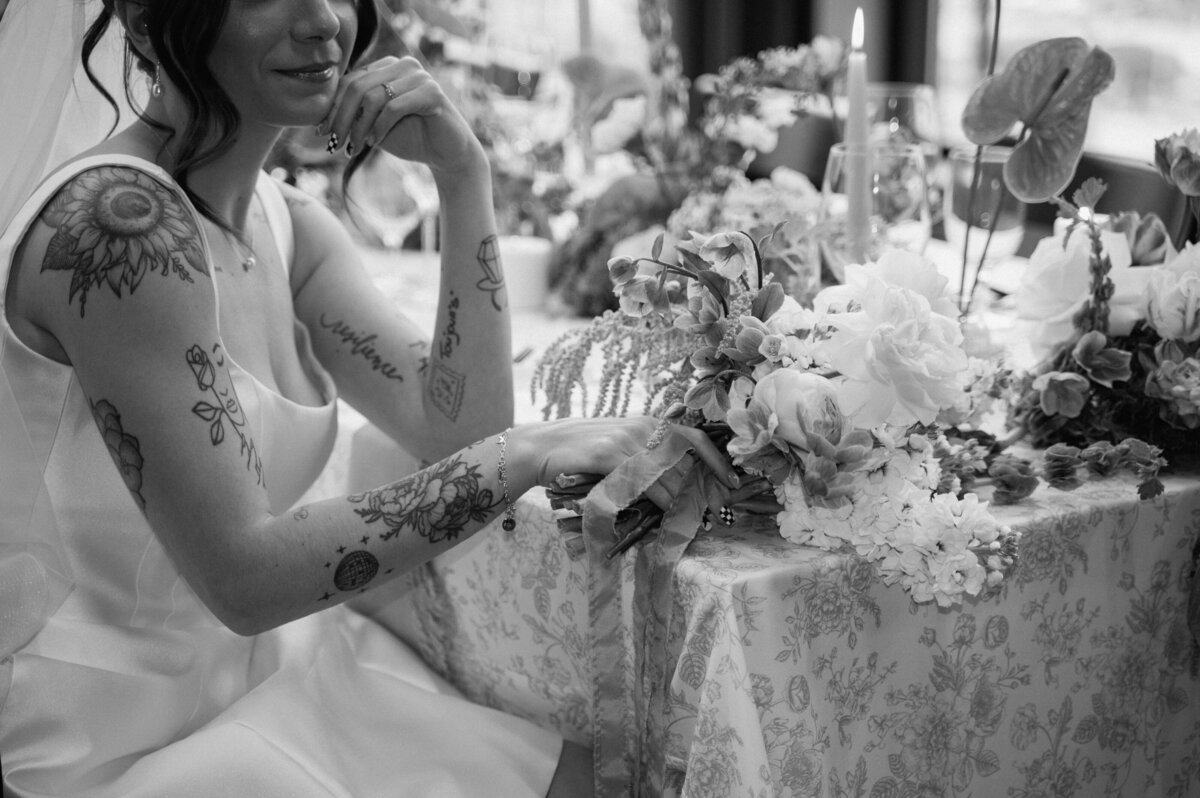 Editorial black and white photo of bride seated at her wedding reception table in Banff.