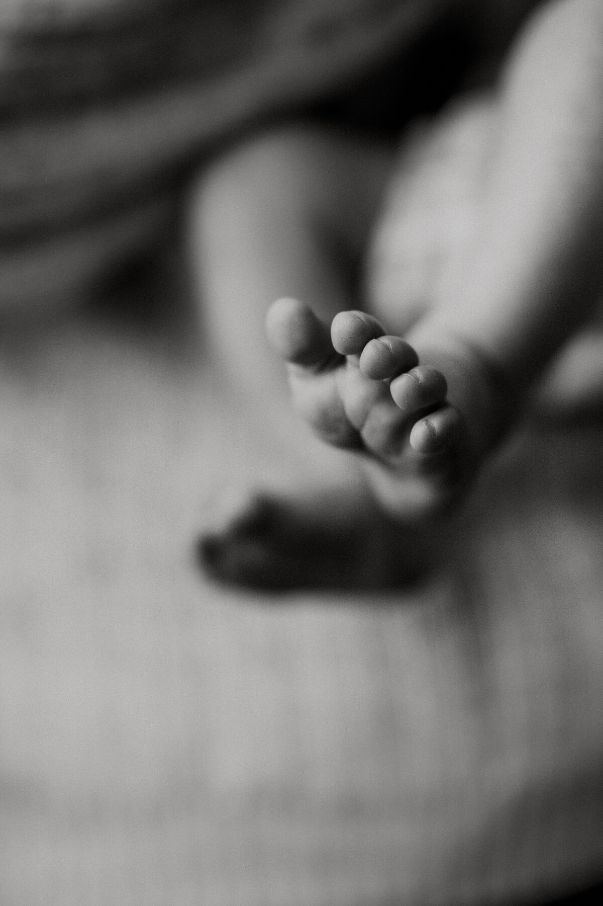 Mother cuddling her newborn baby during a lifestyle newborn photography session in Minnesota.