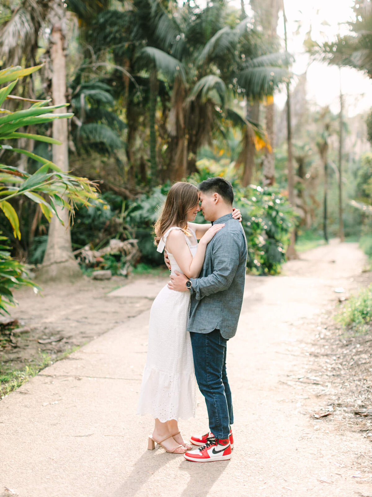 couple standing in the middle of trail path in balboa park san diego