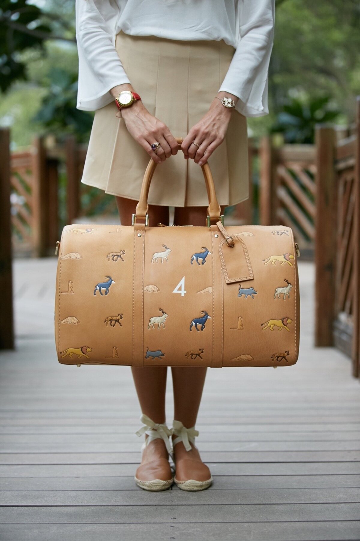 Image of woman holding brown safari bag