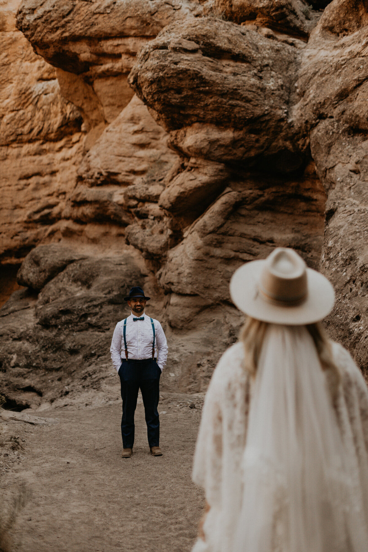 bride walking towards groom in a slot canyon