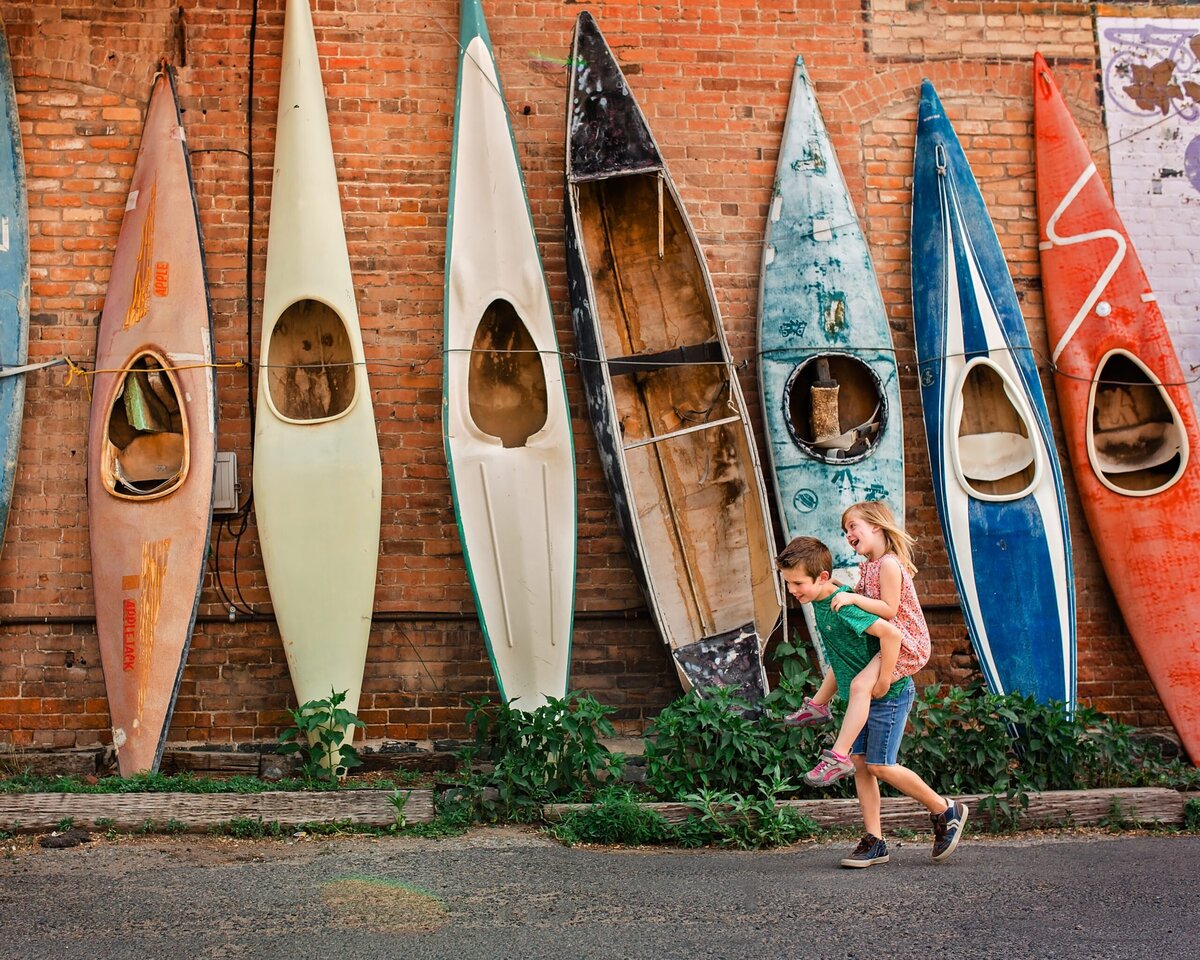 children playing by coloful kayaks 