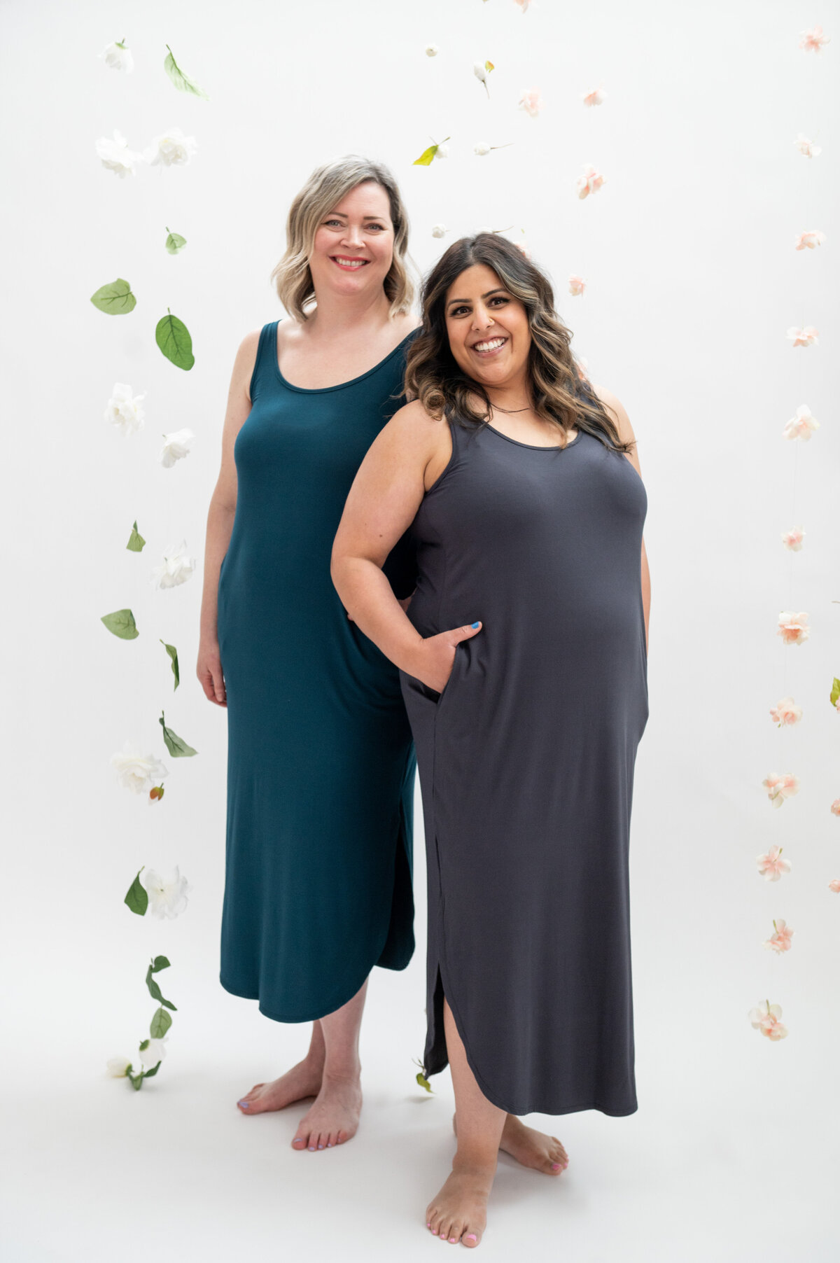 Listing photo of two women wearing maxi dresses on a flower backdrop