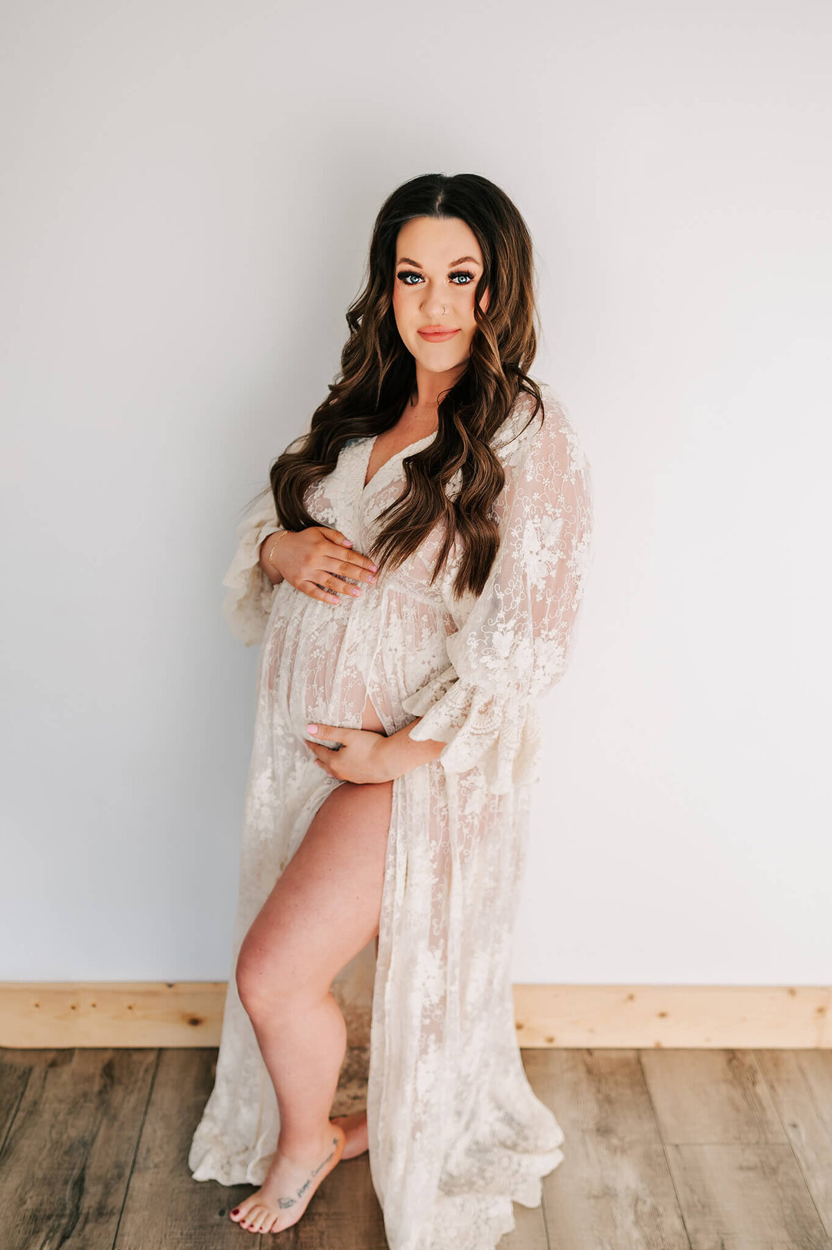 maternity photo in Springfield MO of pregnant mom in lace dress  standing in studio