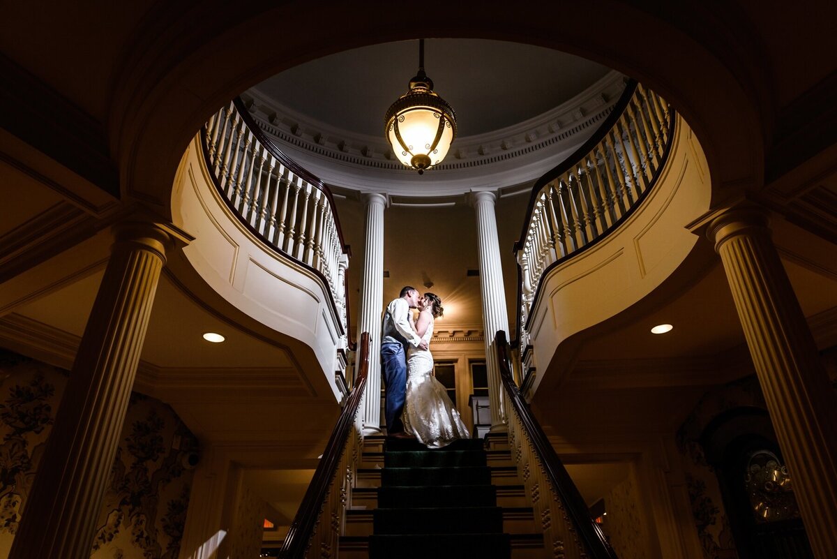 Couple embrace on staircase at Moorland Mansion