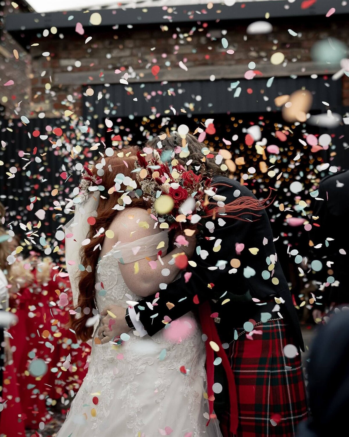 couple kiss in a storm of confetti 
