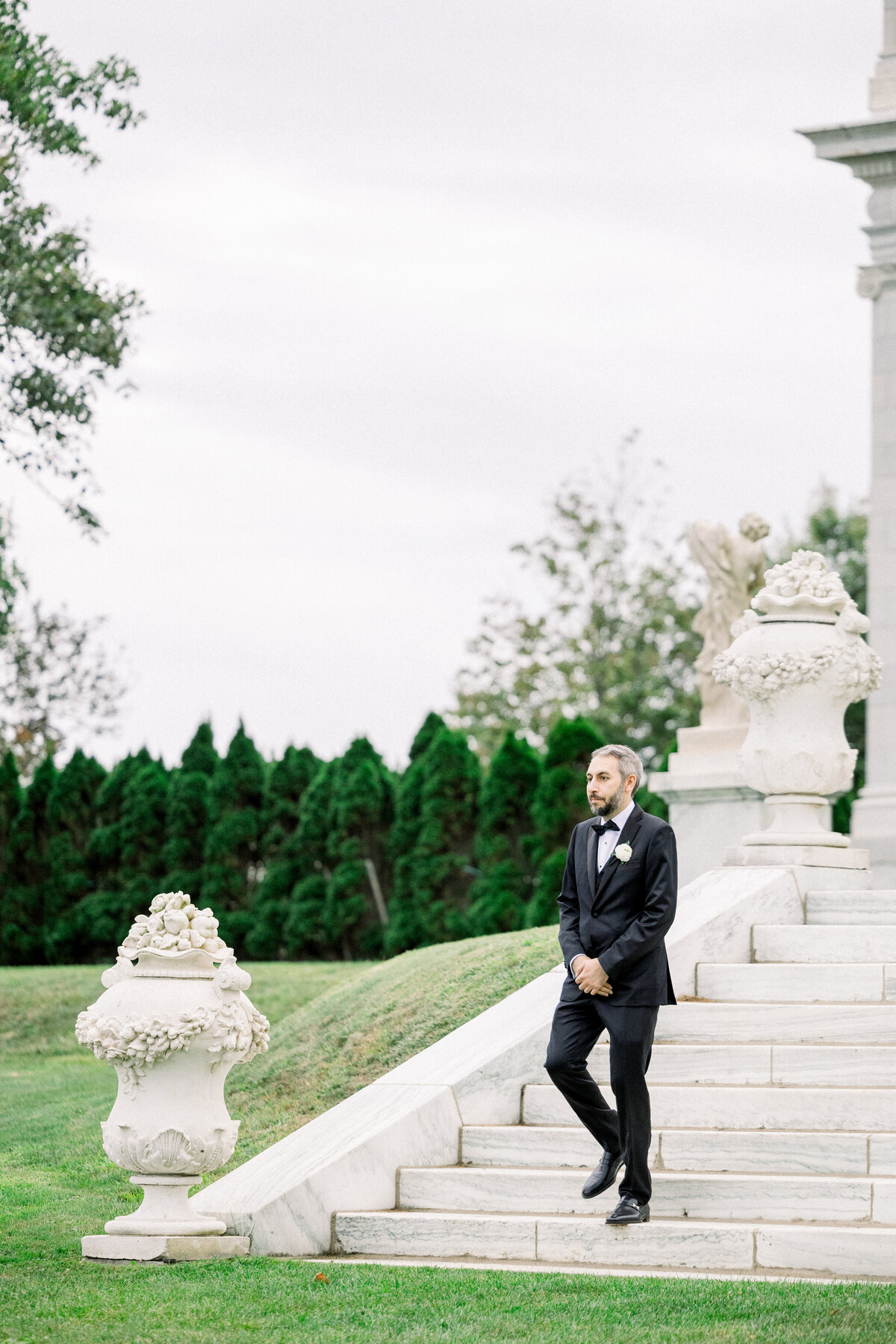 groom walking down the back stairs torwards his oceanside lawn ceremony at rosecliff mansion in newport rhode island