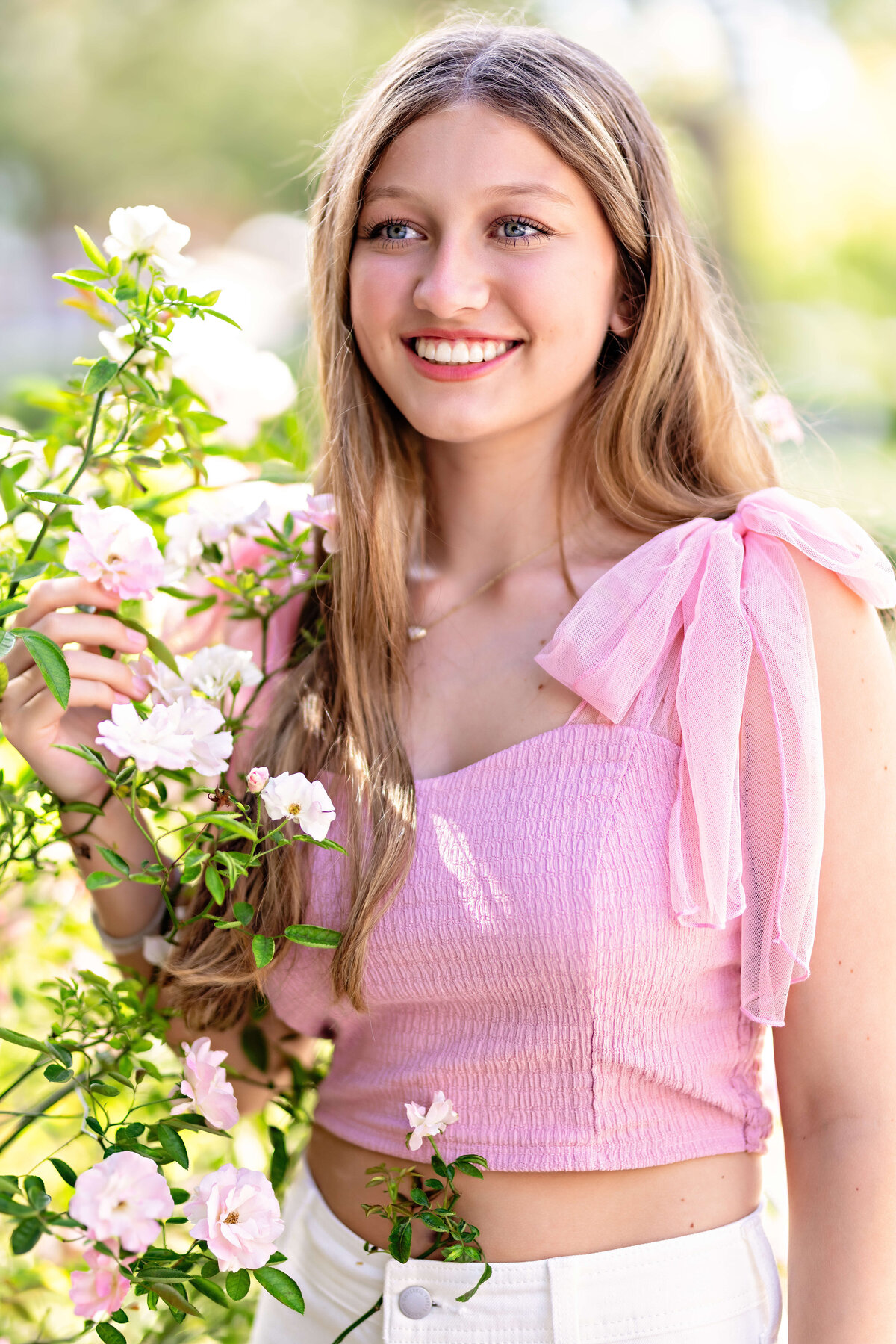 Close-up of high school senior smiling with flowers in hand during Orlando senior session