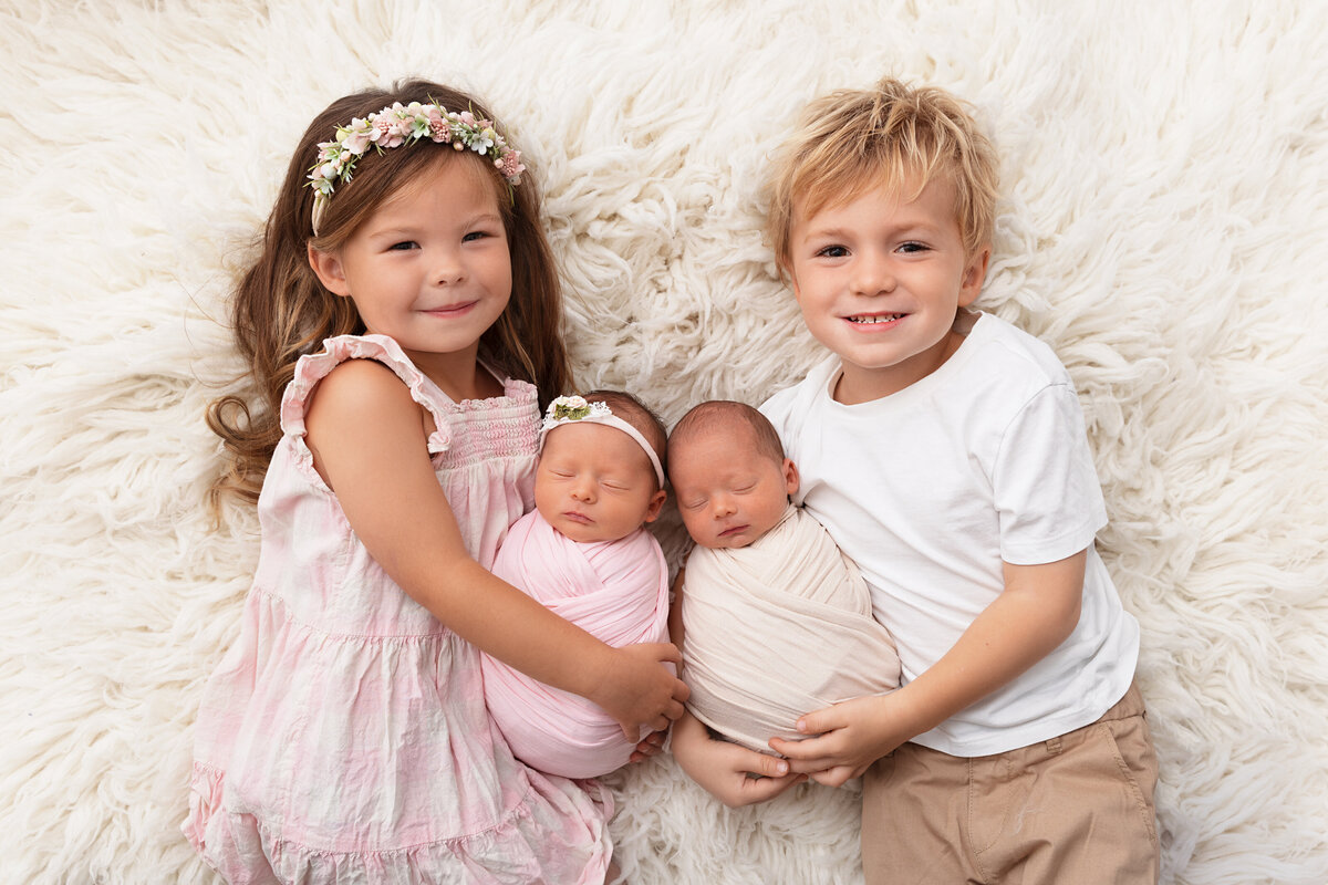 Toddler brother and sister cuddling together during a sibling twin portrait session
