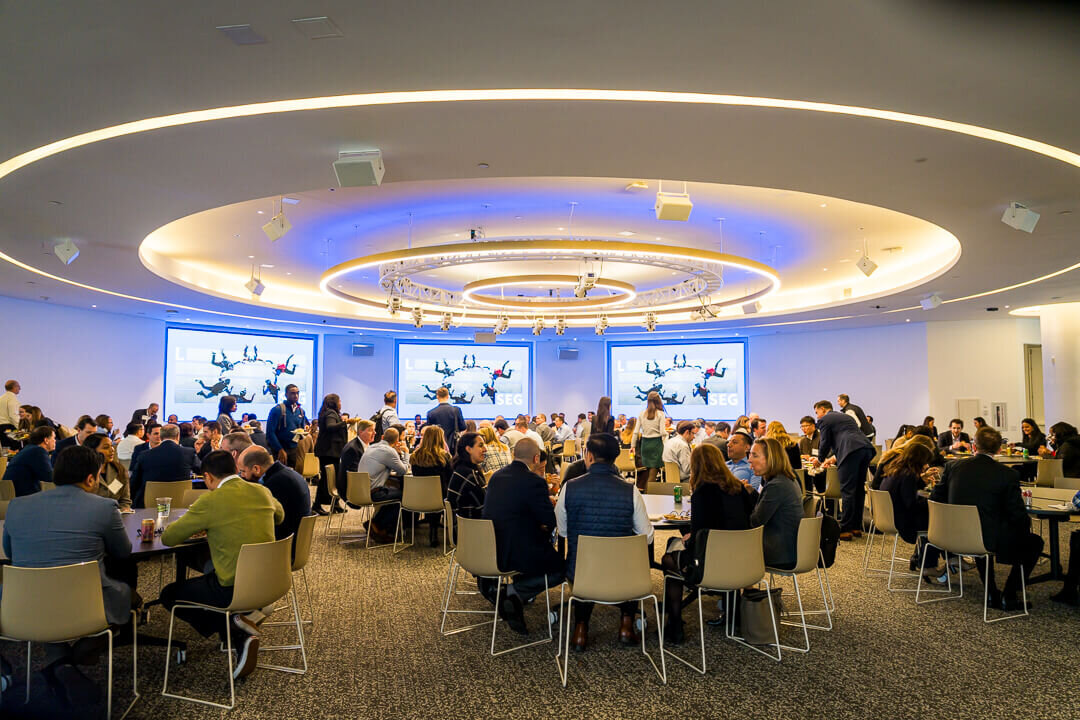 Corporate event photo of presenter with projected slides addressing professional audience new york.