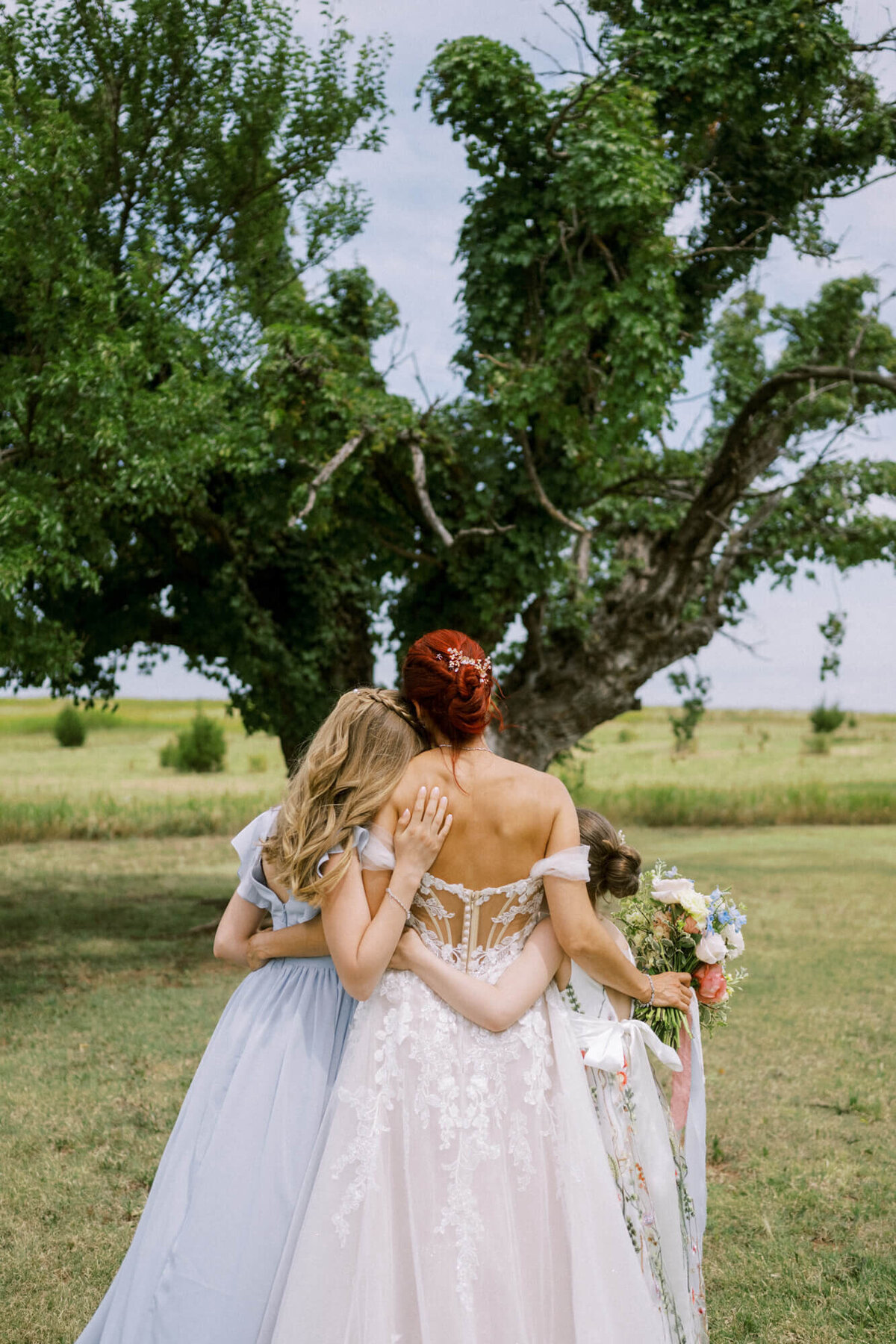 mom-and-daughters-embrace-from-behind