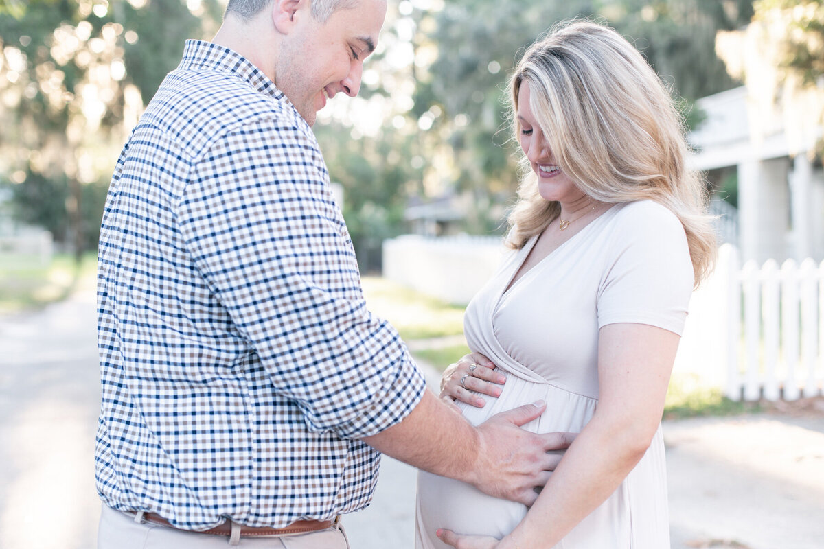 Expectant parents holding pregnant mother's baby bump during maternity photography session in Savannah GA