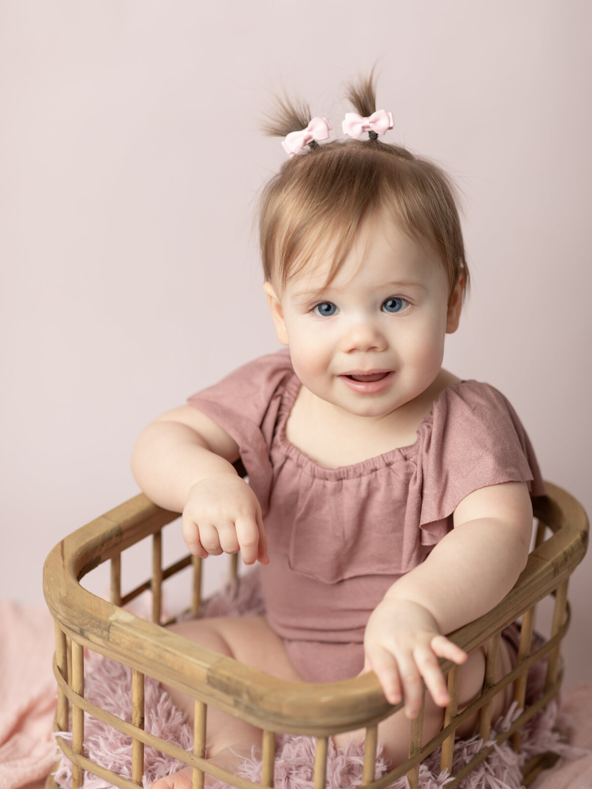 one year old girl in pink for first birthday photoshoot