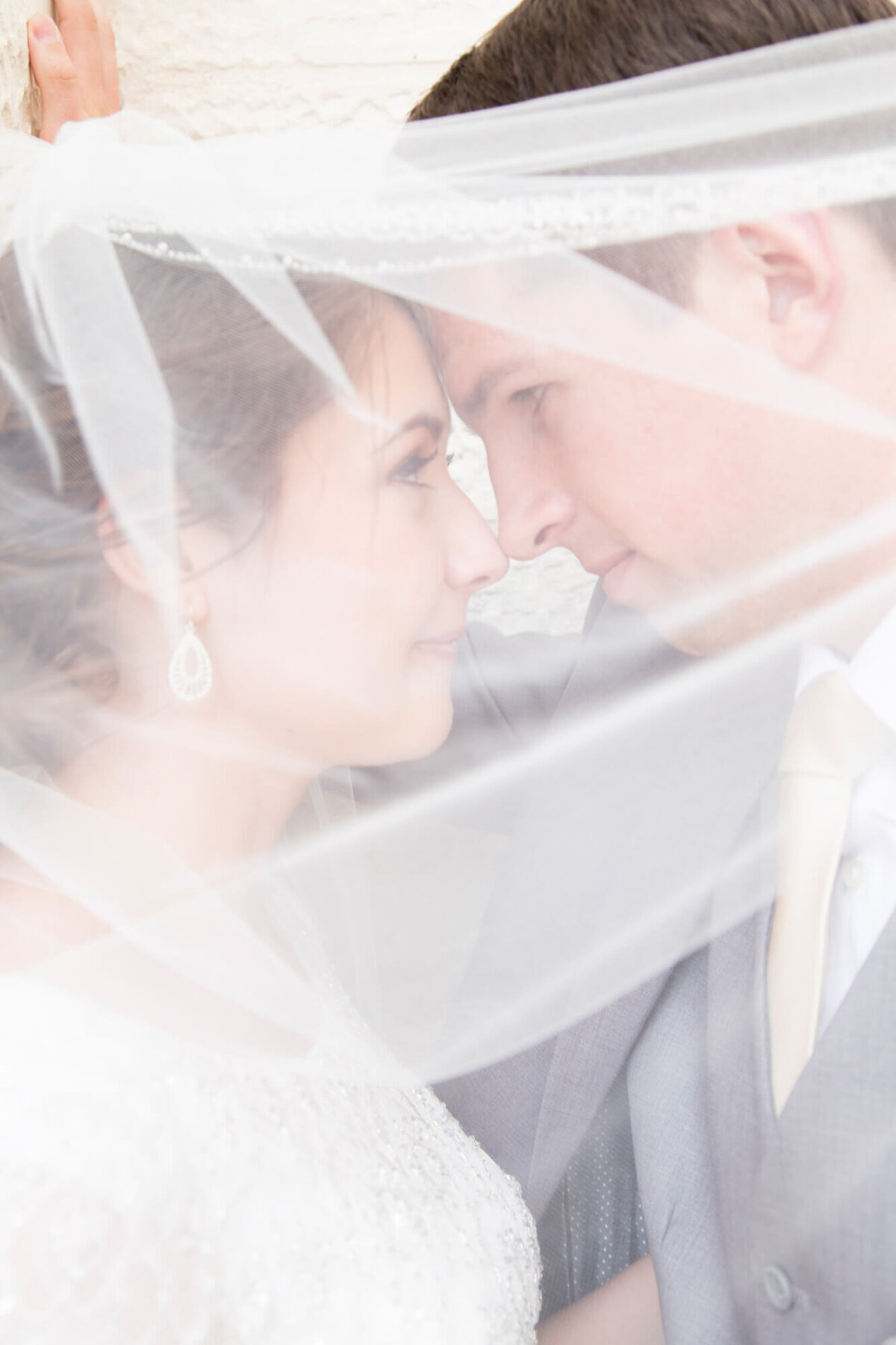 light and airy wedding photography by Jessica Bowles of a couple thoughtfully looking at each other under a veil