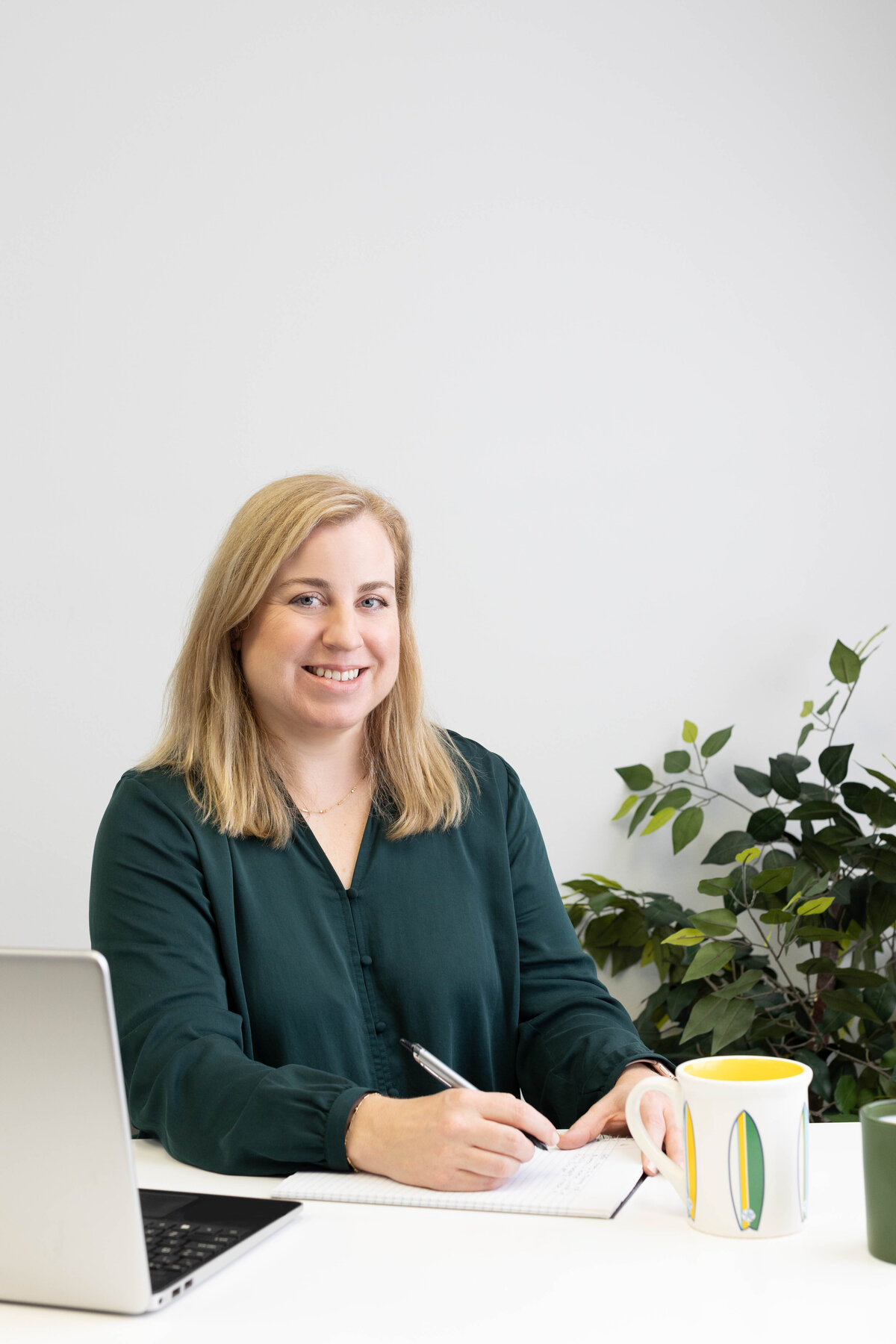 Businesswoman at desk with plant