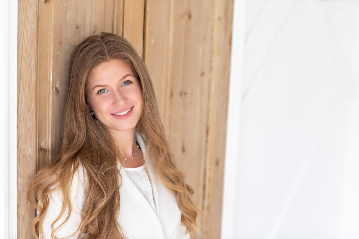 Philadelphia headshot of a young woman leaning casually on a doorframe