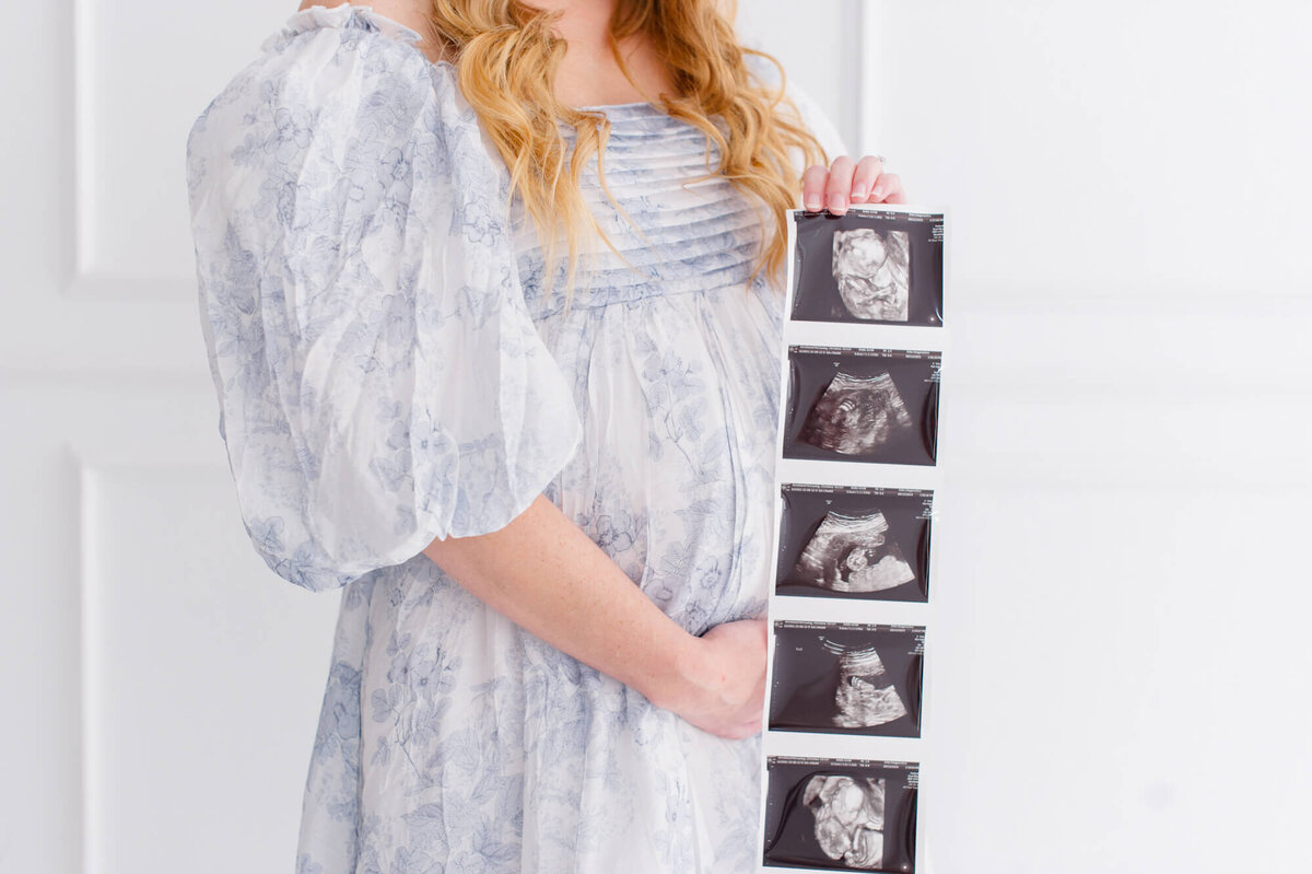Mom holding up her sonogram of baby boy during her maternity session