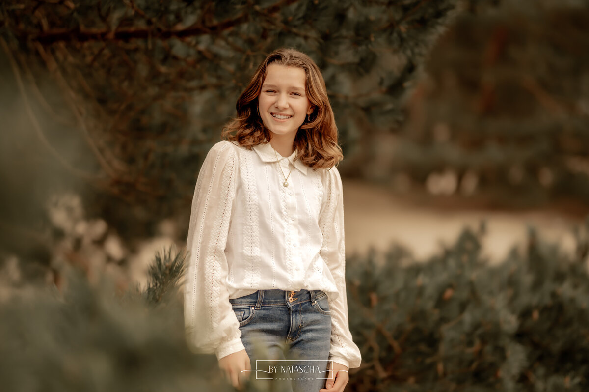 Tiener tussen de takken van het bos voor een portretfoto