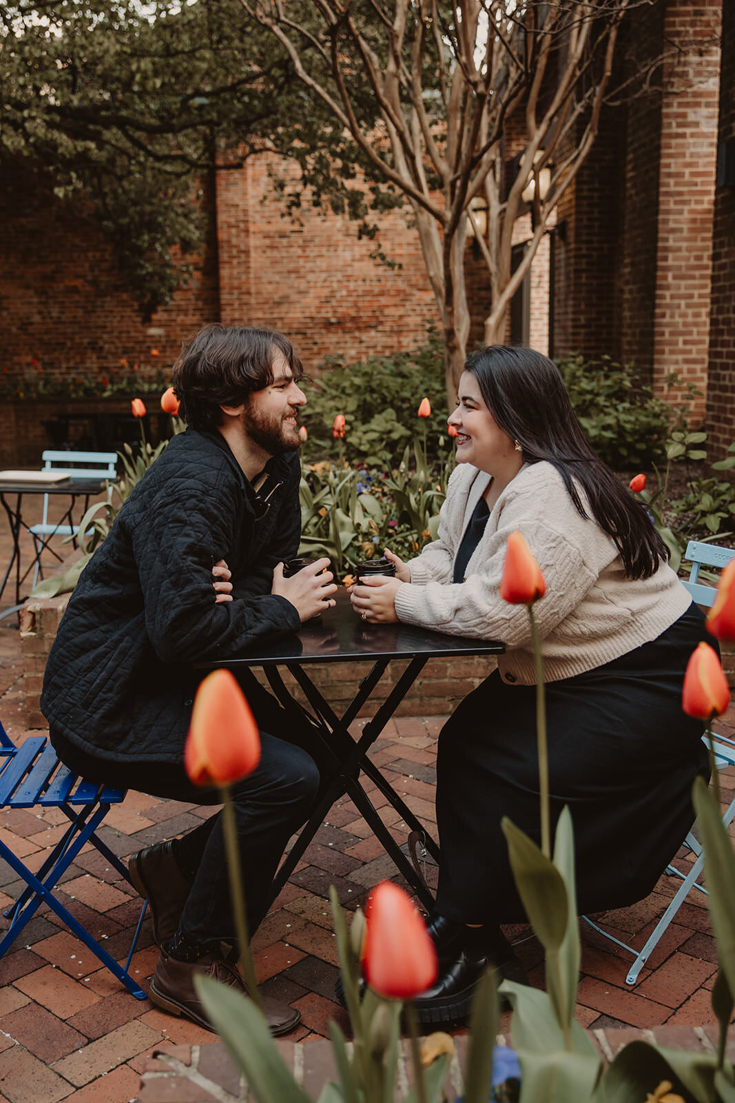 A couple sitting at a small cafe table on a patio