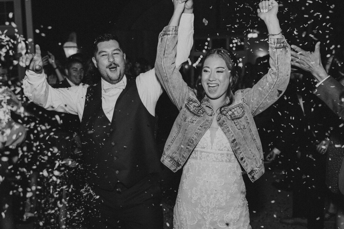 black and white photo of couple walking through confetti at luxury wedding venue in Sacramento, CA