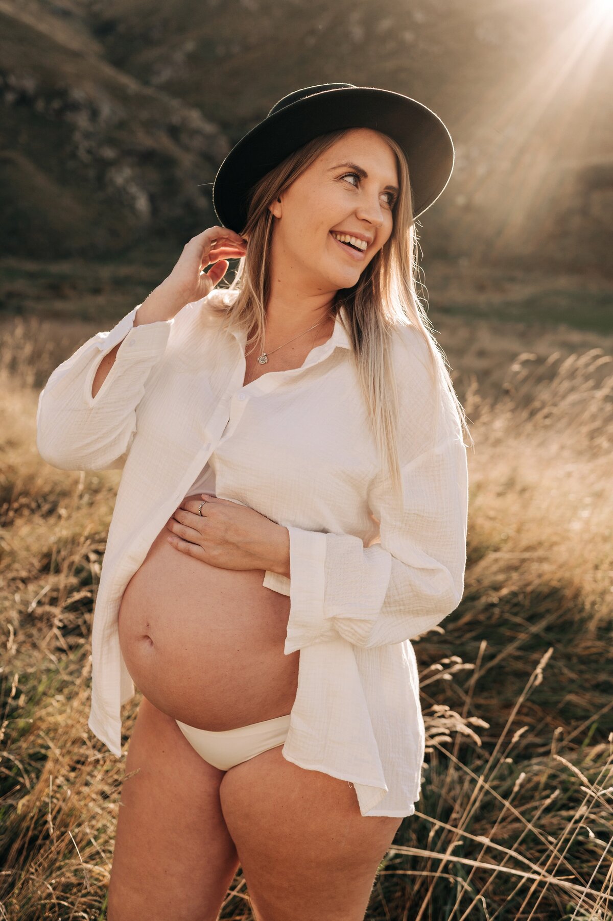 maternity taylors mistake christchurch photographer white lace dress at beach in water winter best candid long dry grass white shirt green hat