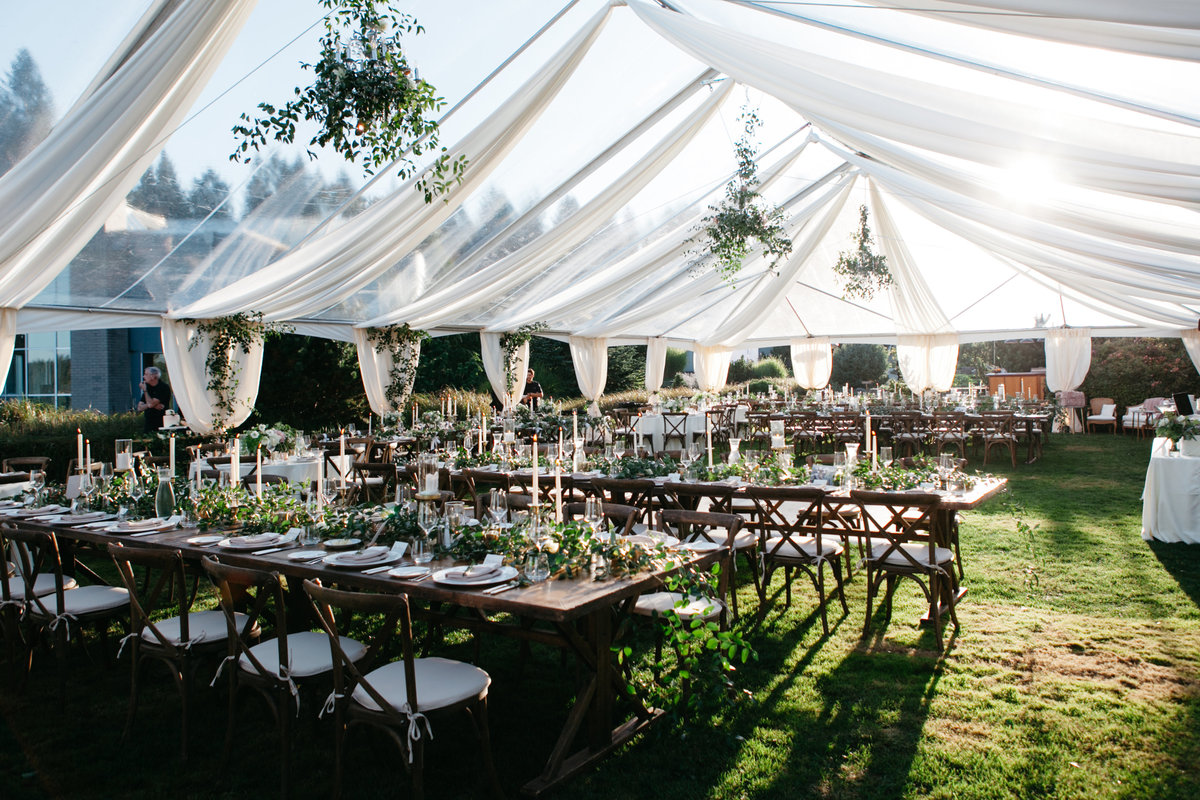 Dreamy greenery themed tent wedding with green vine chandeliers.
