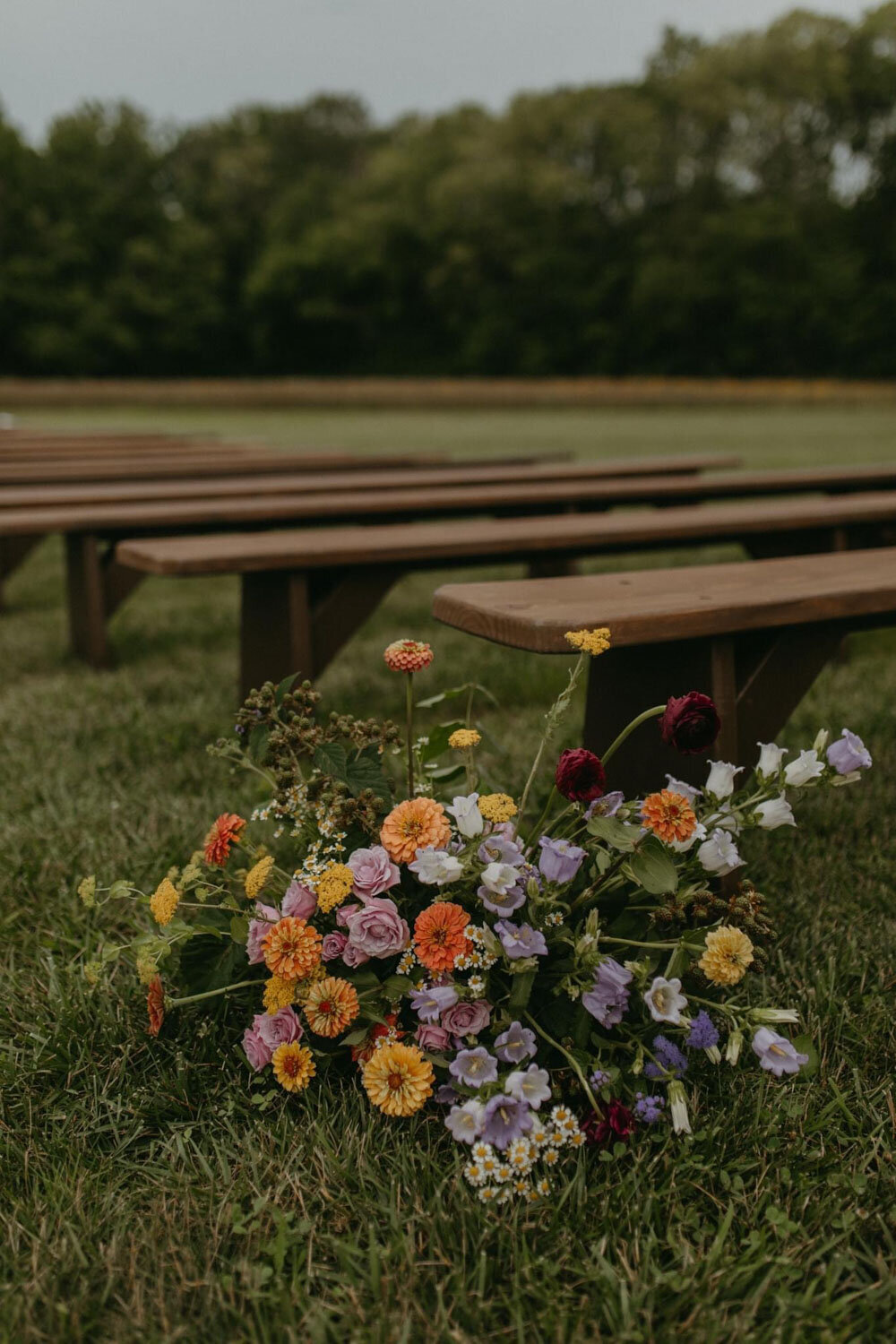 Vibrant floral arrangement placed beside wooden benches