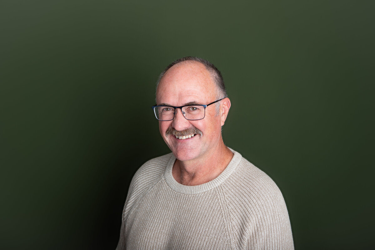 Author headshot on a green backdrop