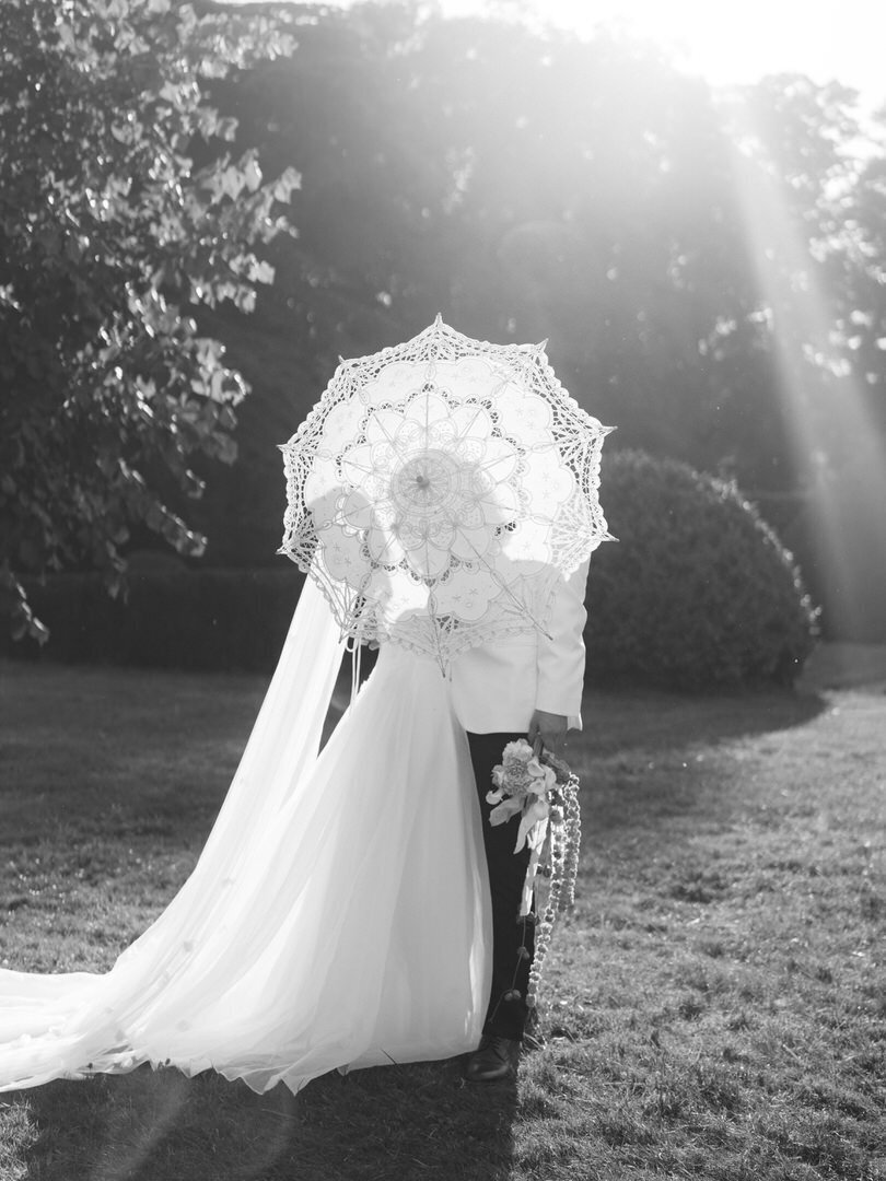 bride and groom holding parasol