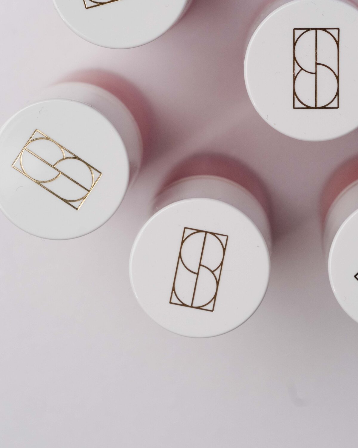 Modern brand icon in gold foil on a Sonela Beauty cosmetic product, designed by Sarah Shuttle